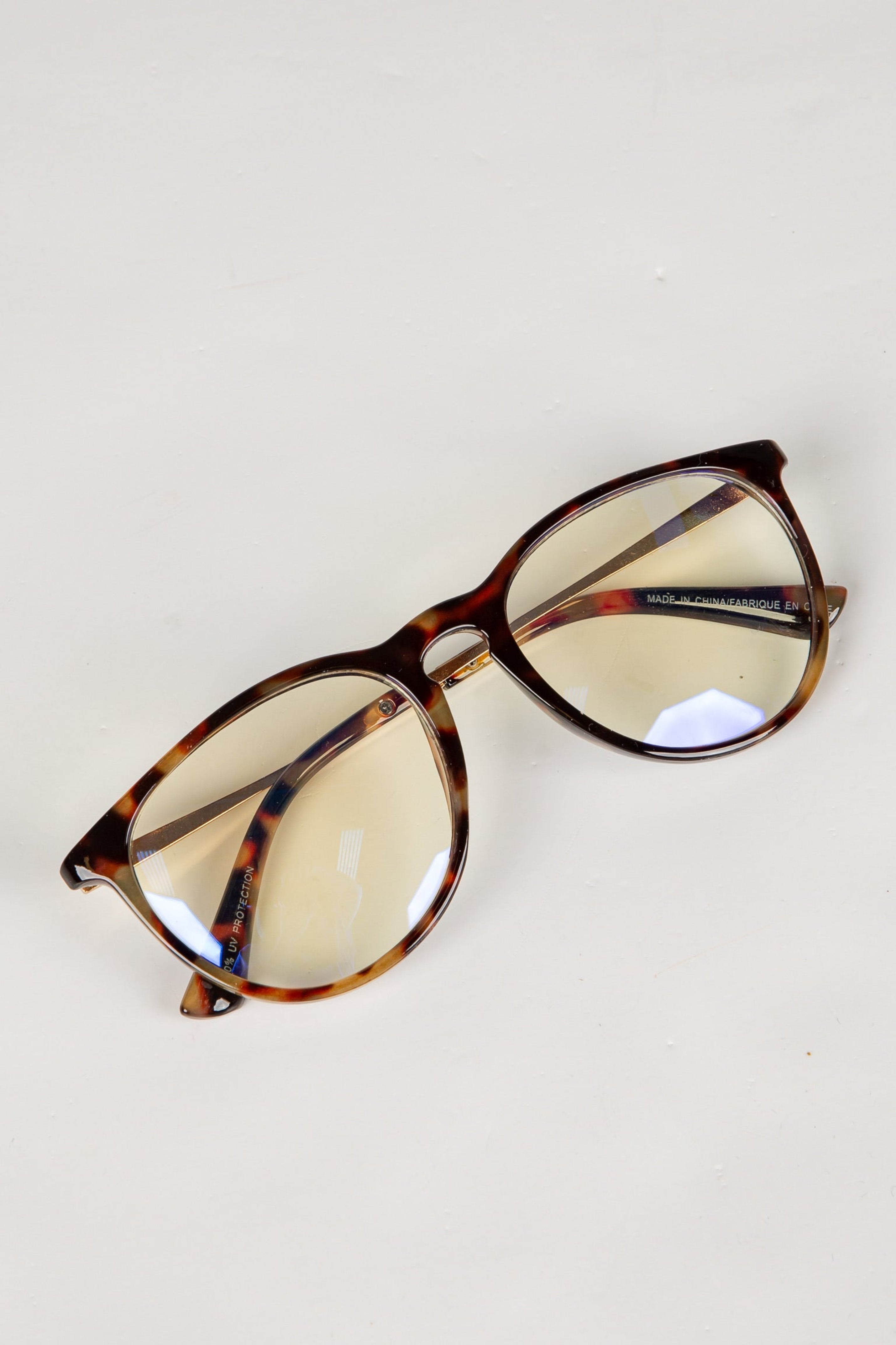 Tortoiseshell glasses with yellow-tinted lenses on a white background