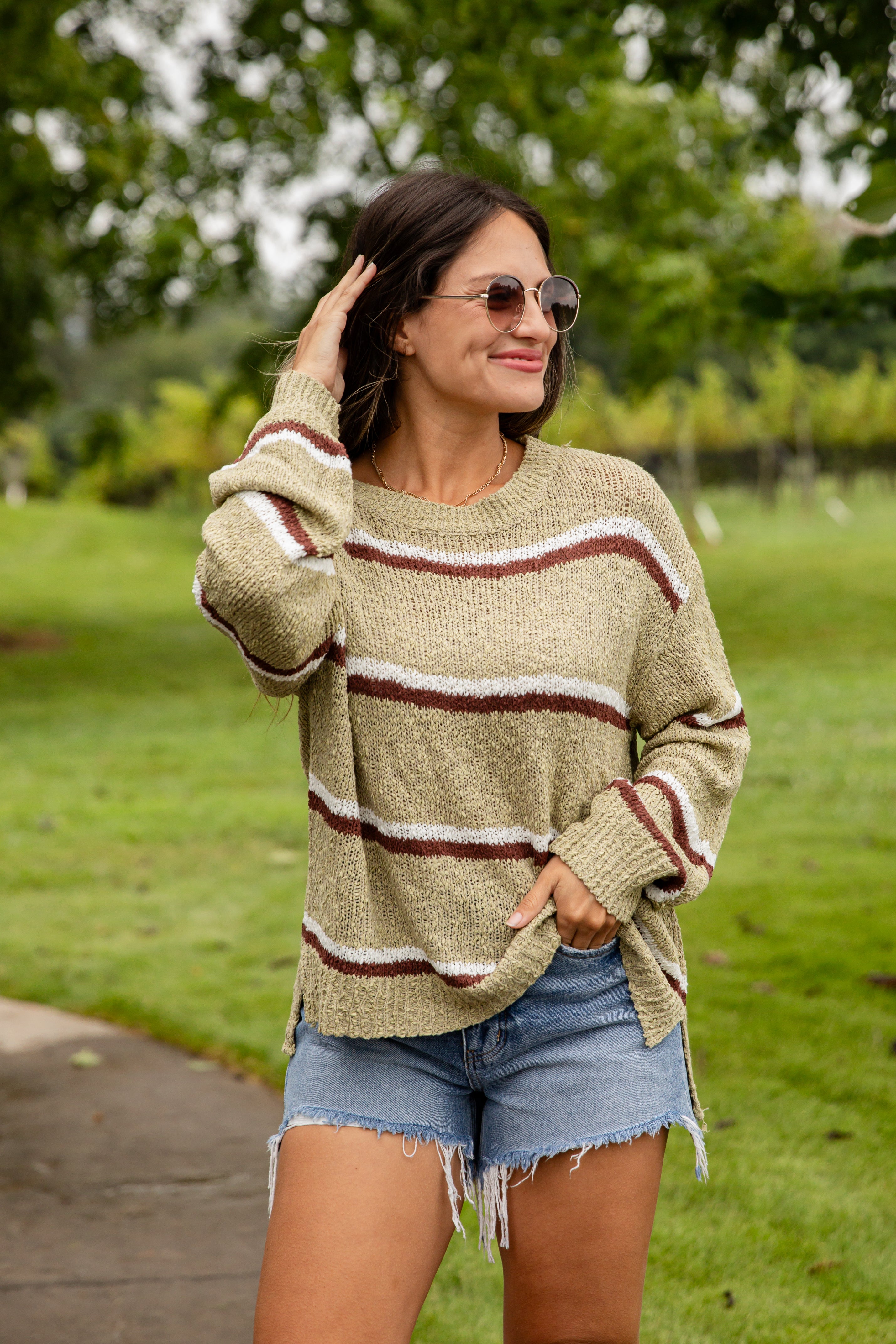 Woman wearing a striped sweater and denim shorts outdoors