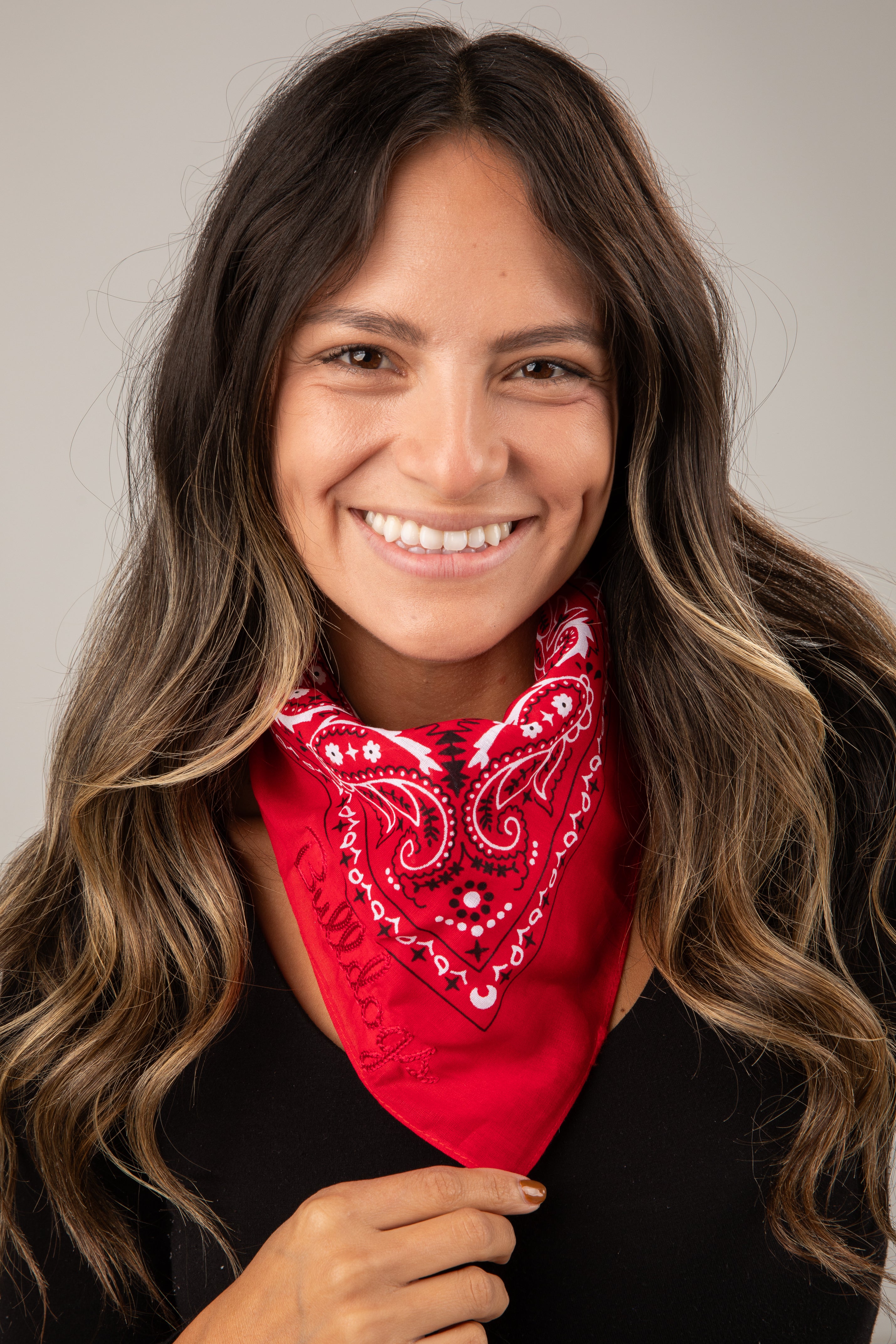 Woman wearing a red bandana with a pattern against a neutral background