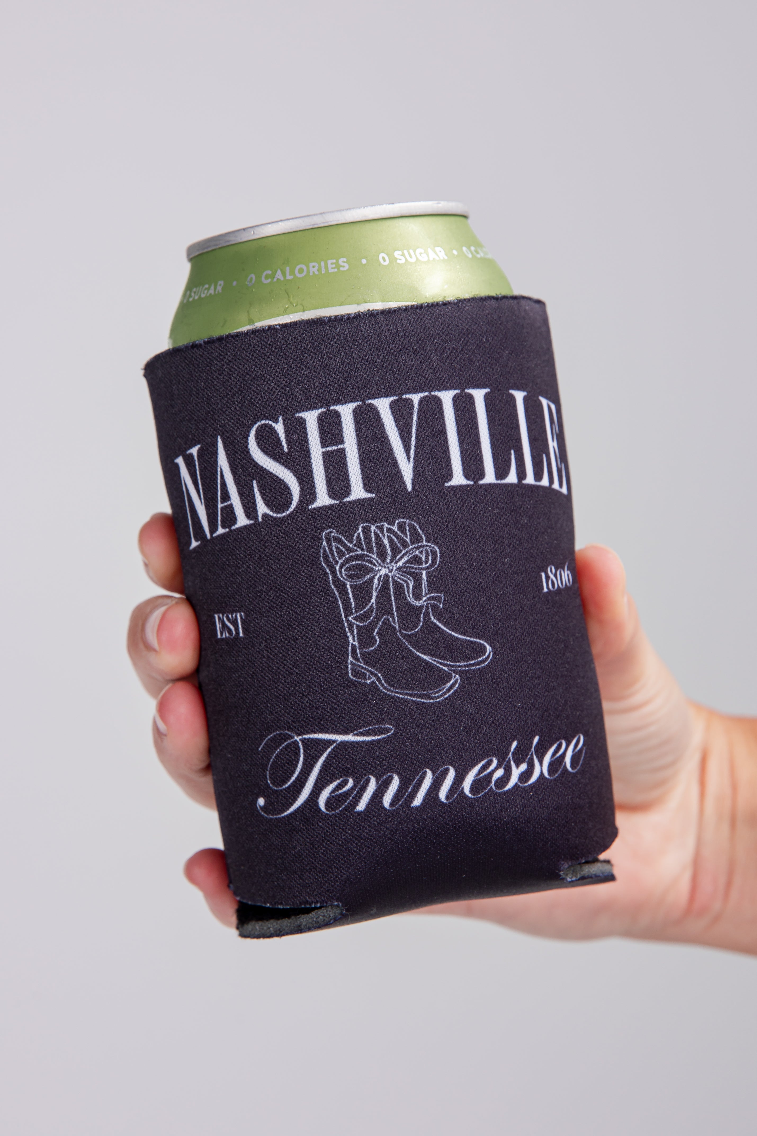 Hand holding a can with a Nashville, Tennessee-themed can cooler.