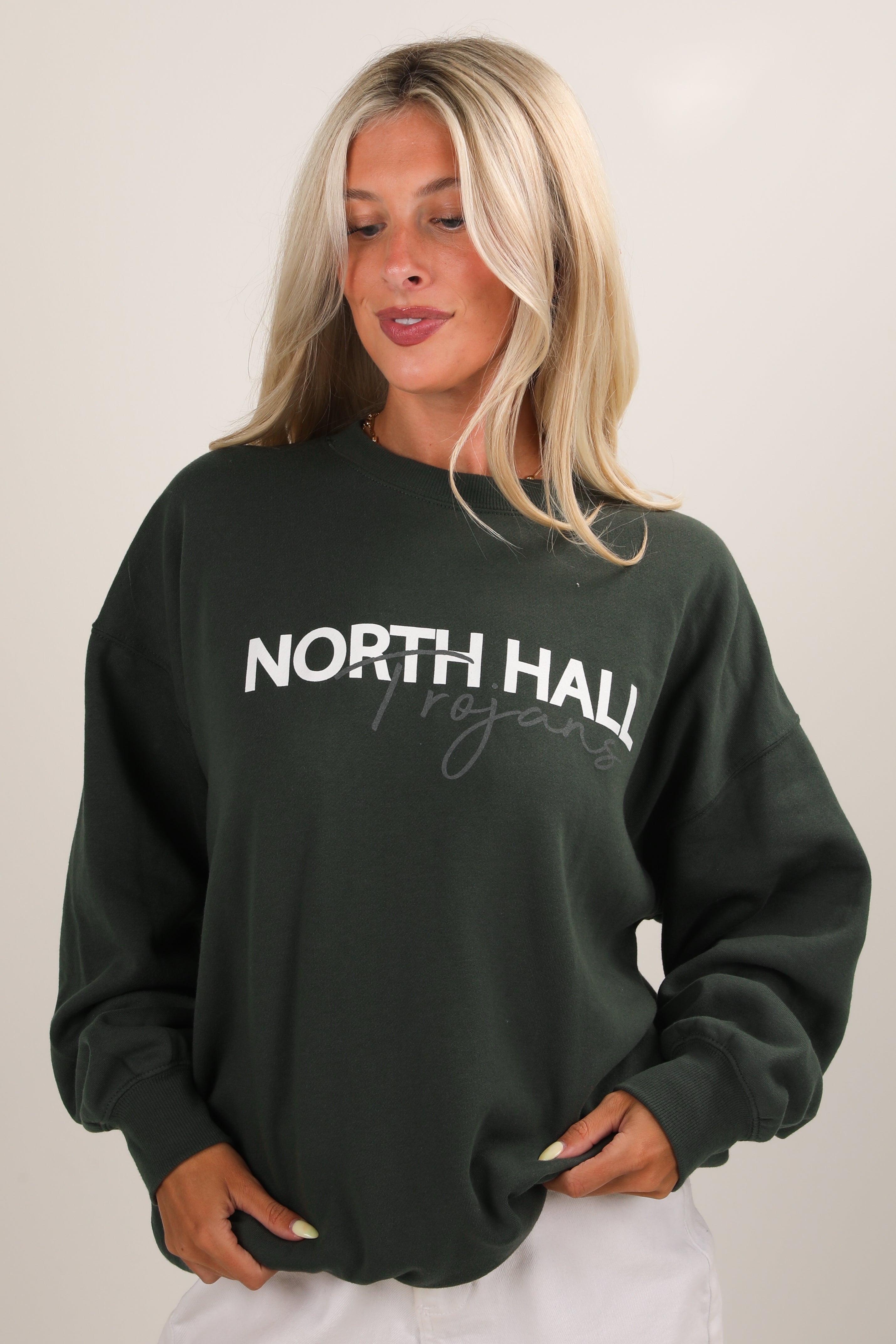 Woman wearing a dark green sweatshirt with &