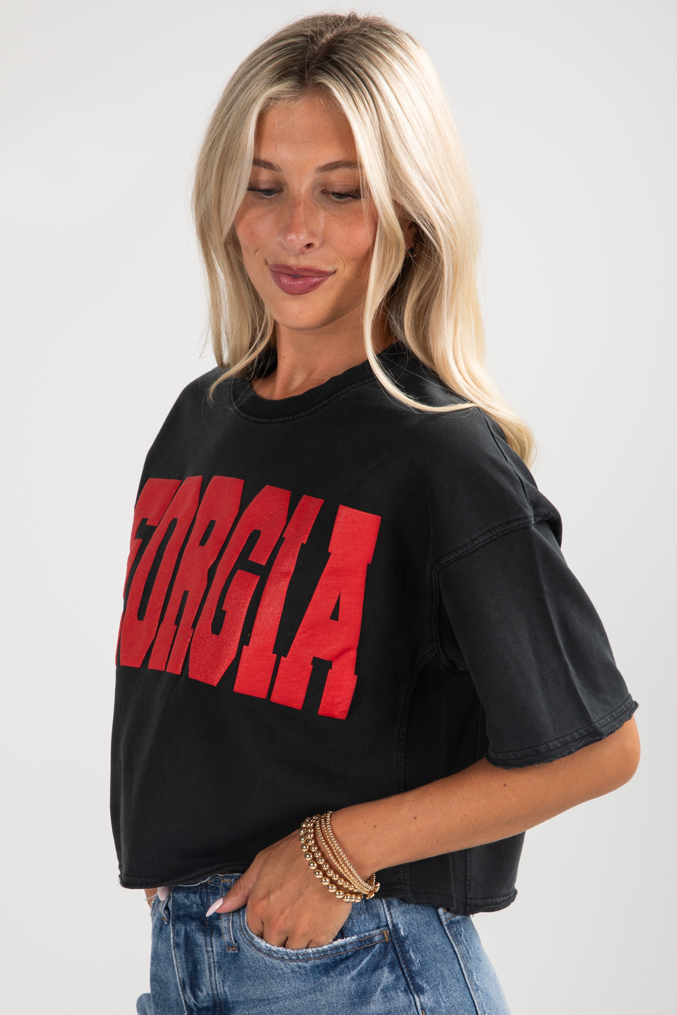 Woman wearing a black oversized t-shirt with red text on a white background