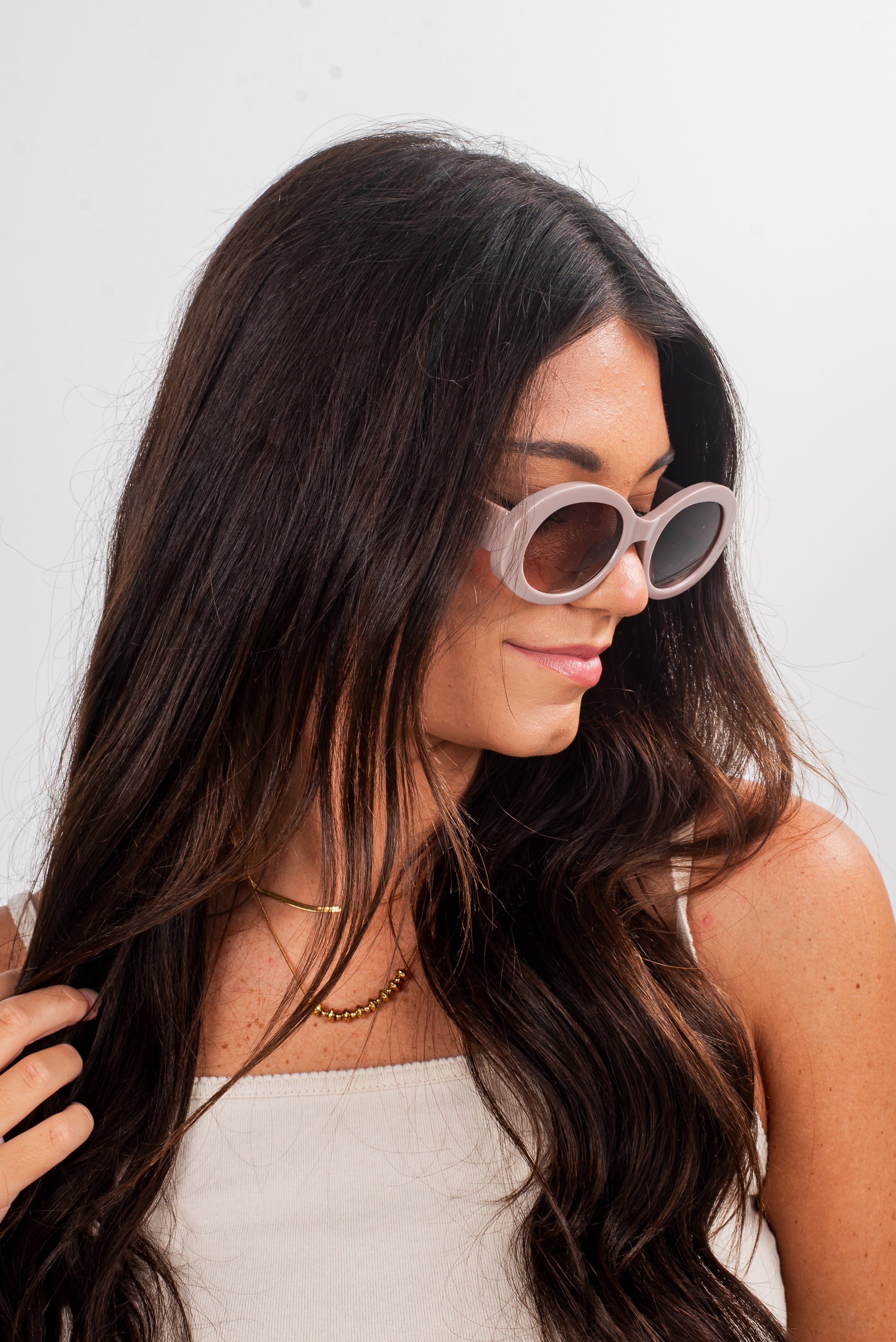 Woman wearing sunglasses with a plain background