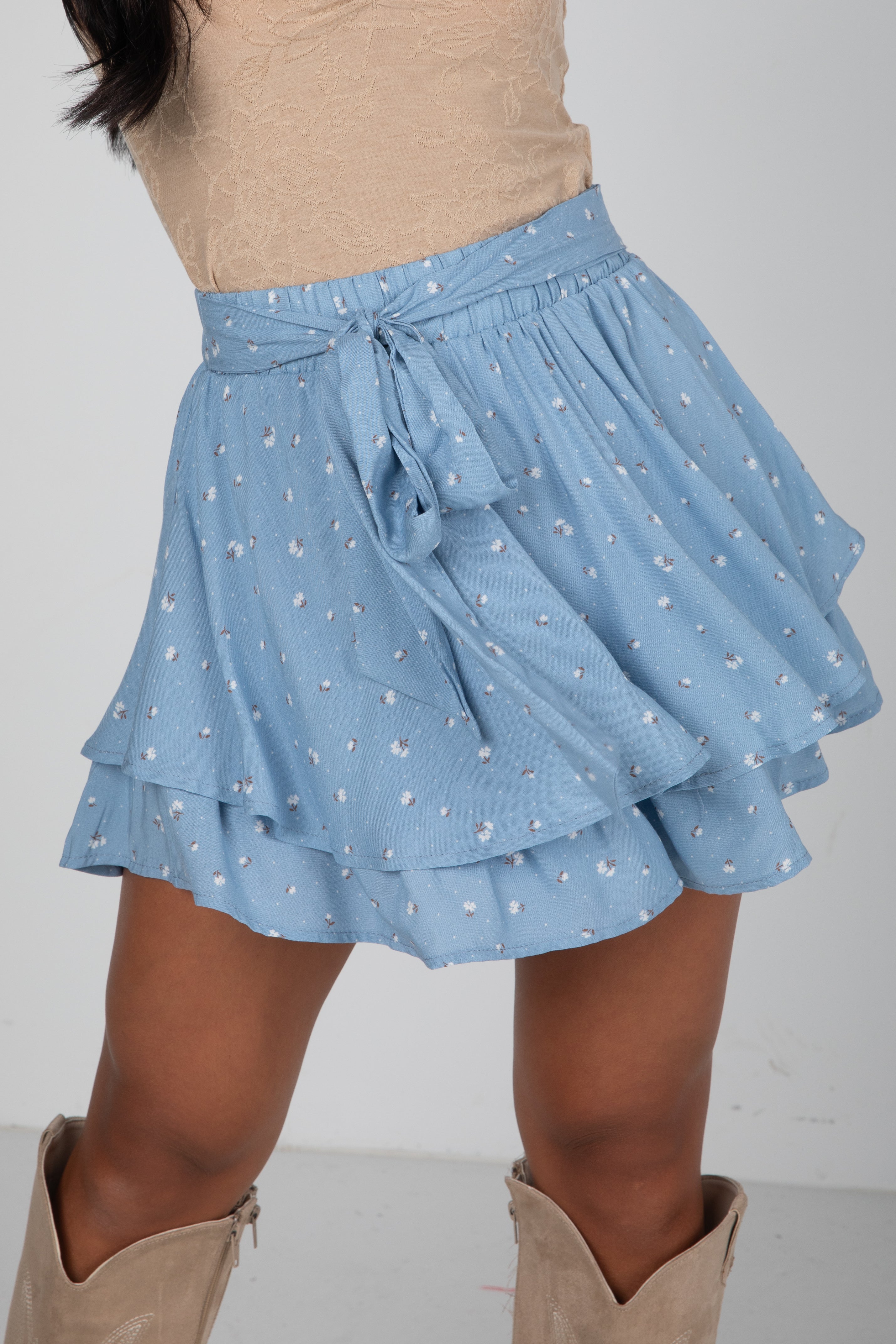 Light blue tiered skirt with floral pattern worn by a person on a white background