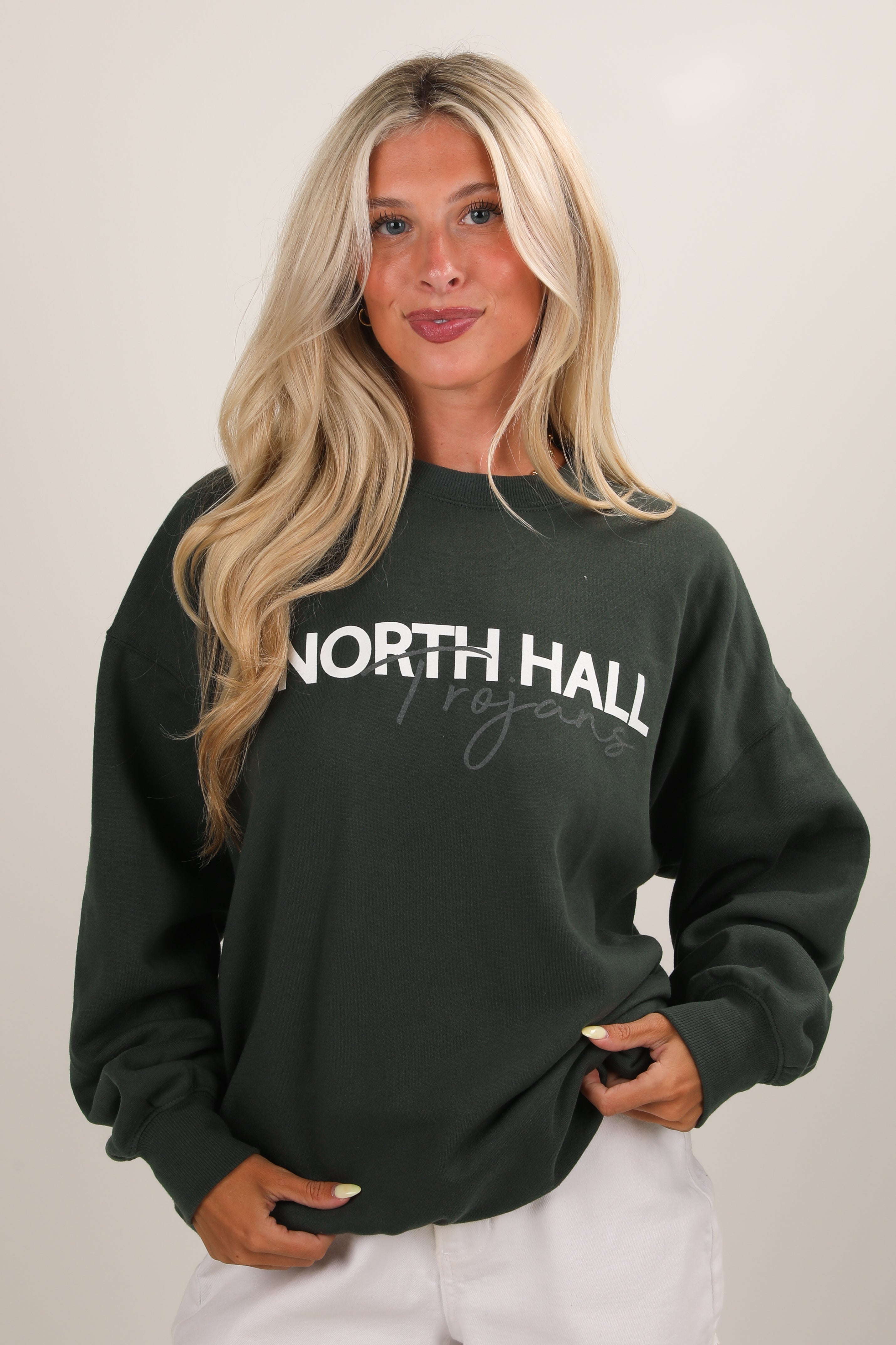 Woman wearing a dark green sweatshirt with &
