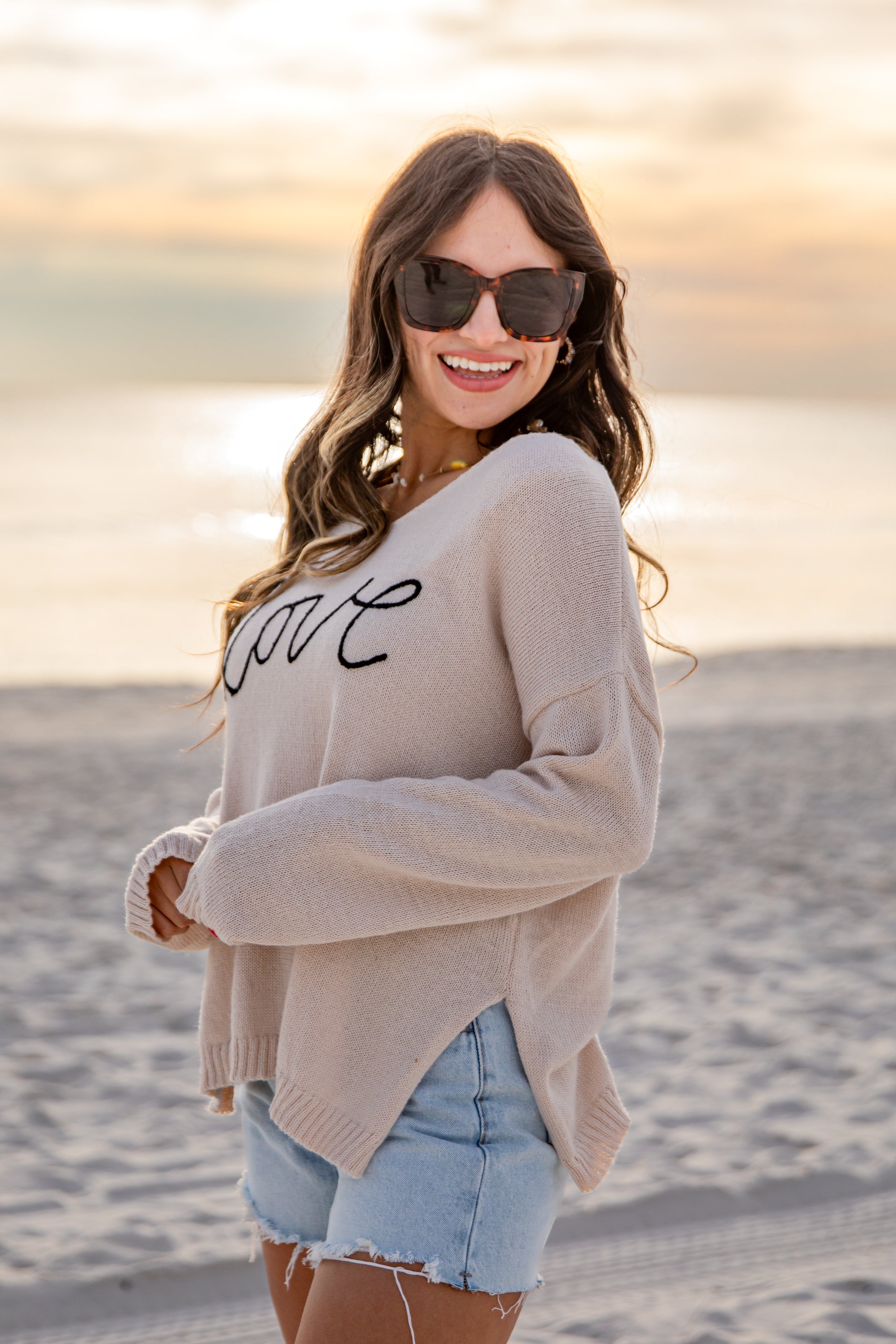 Woman wearing a beige sweater with &