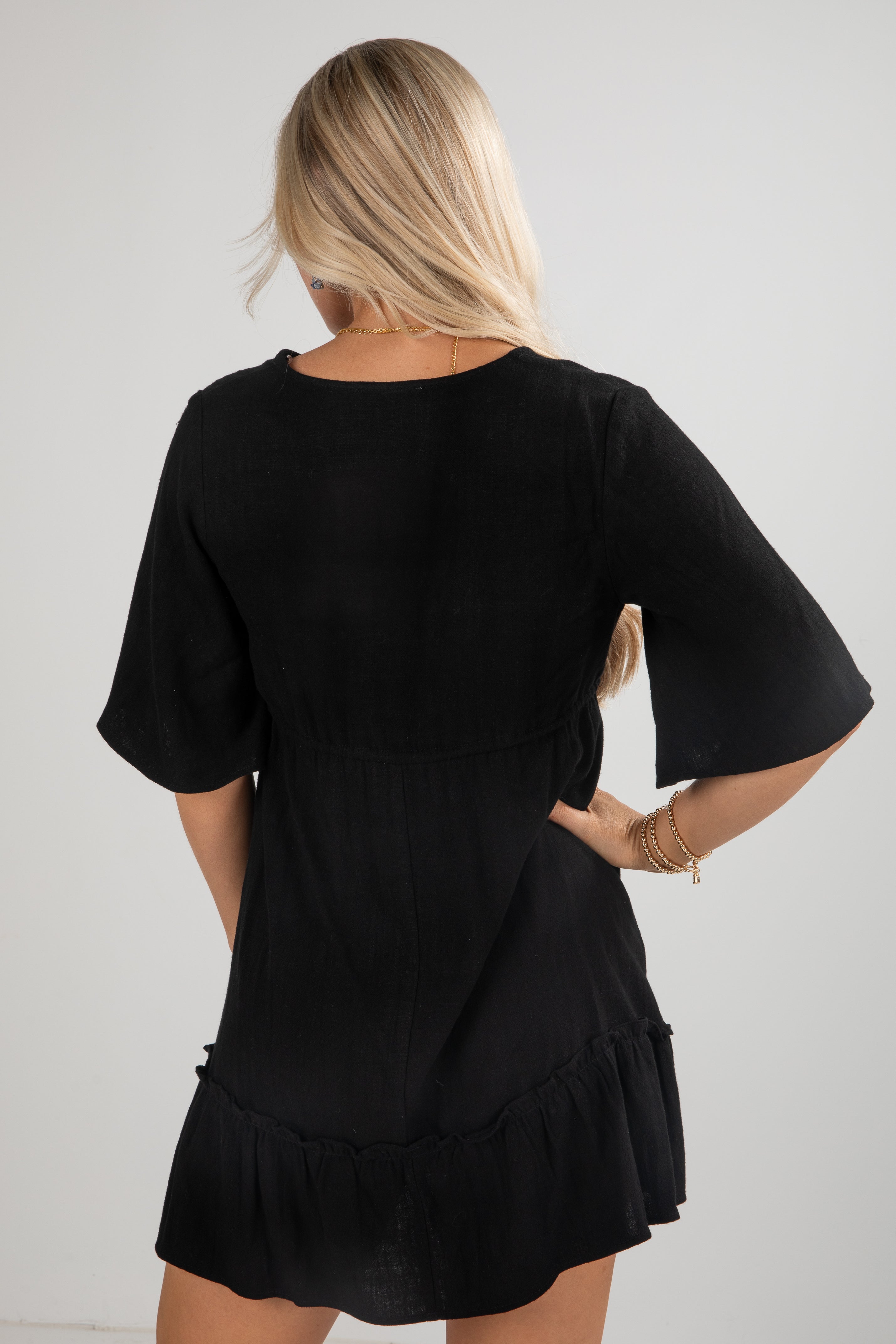 Black dress worn by a person on a plain background