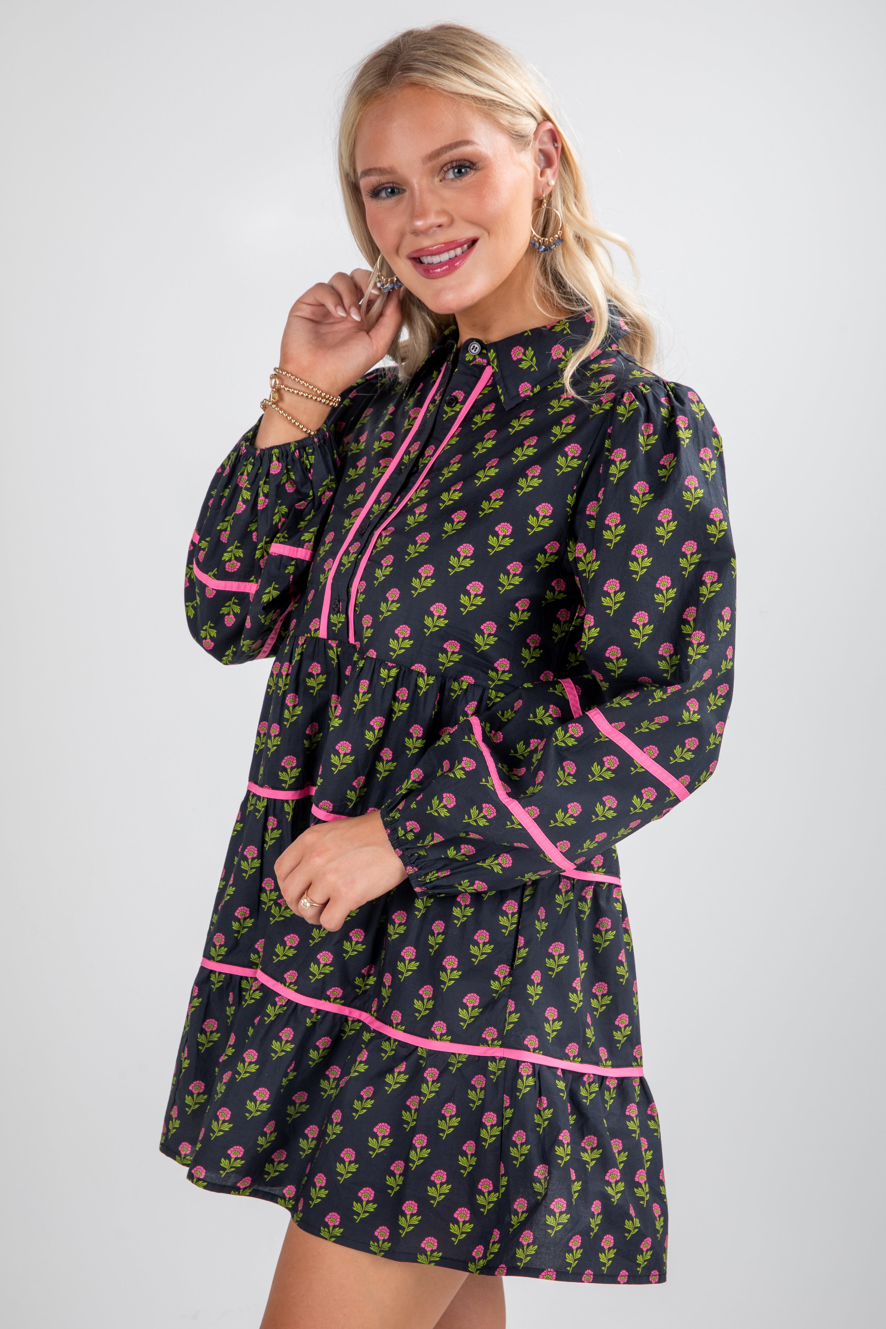 Woman wearing a floral dress with pink accents on a white background