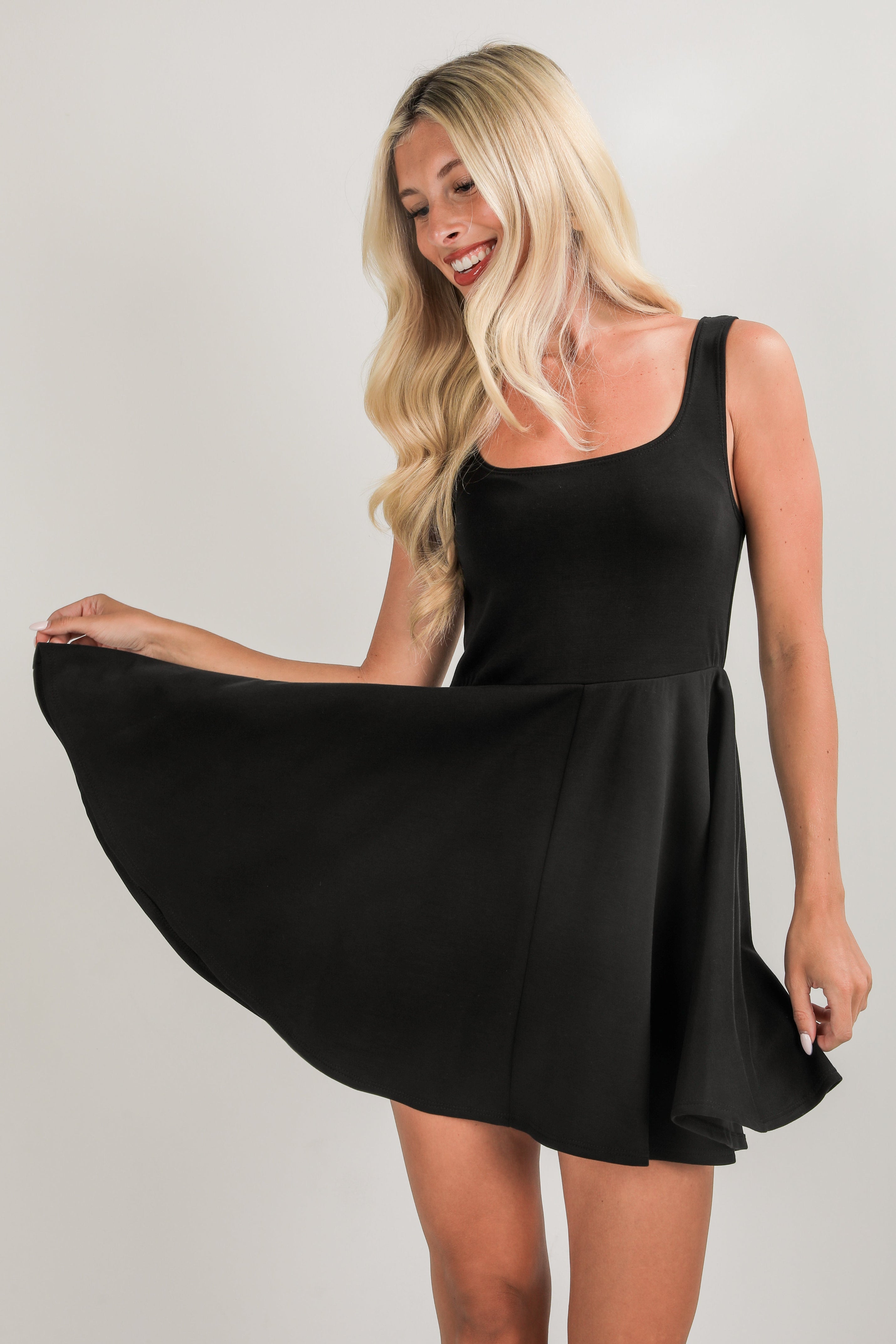 Woman wearing a black dress against a plain background