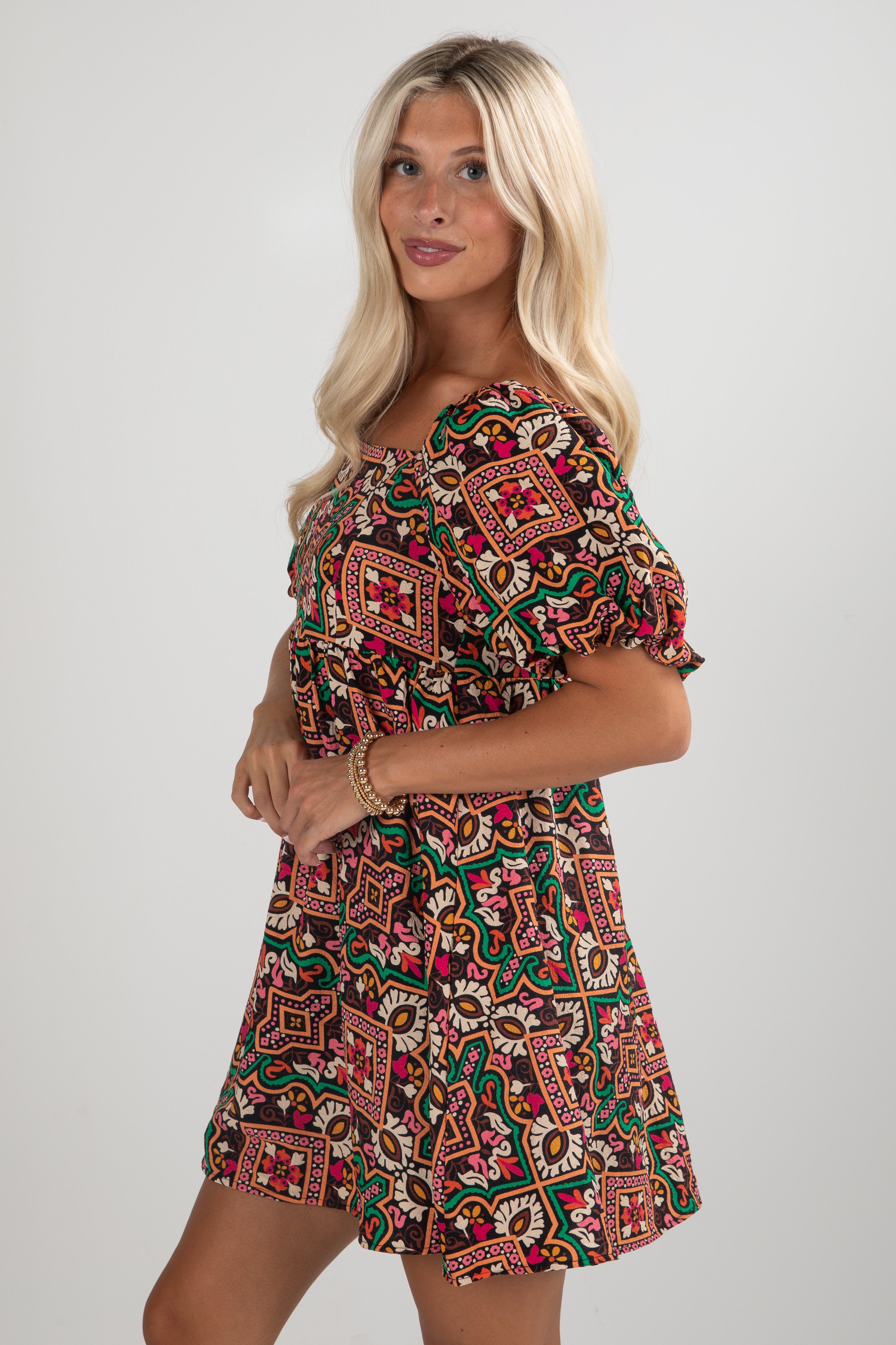 Woman wearing a patterned dress on a plain background