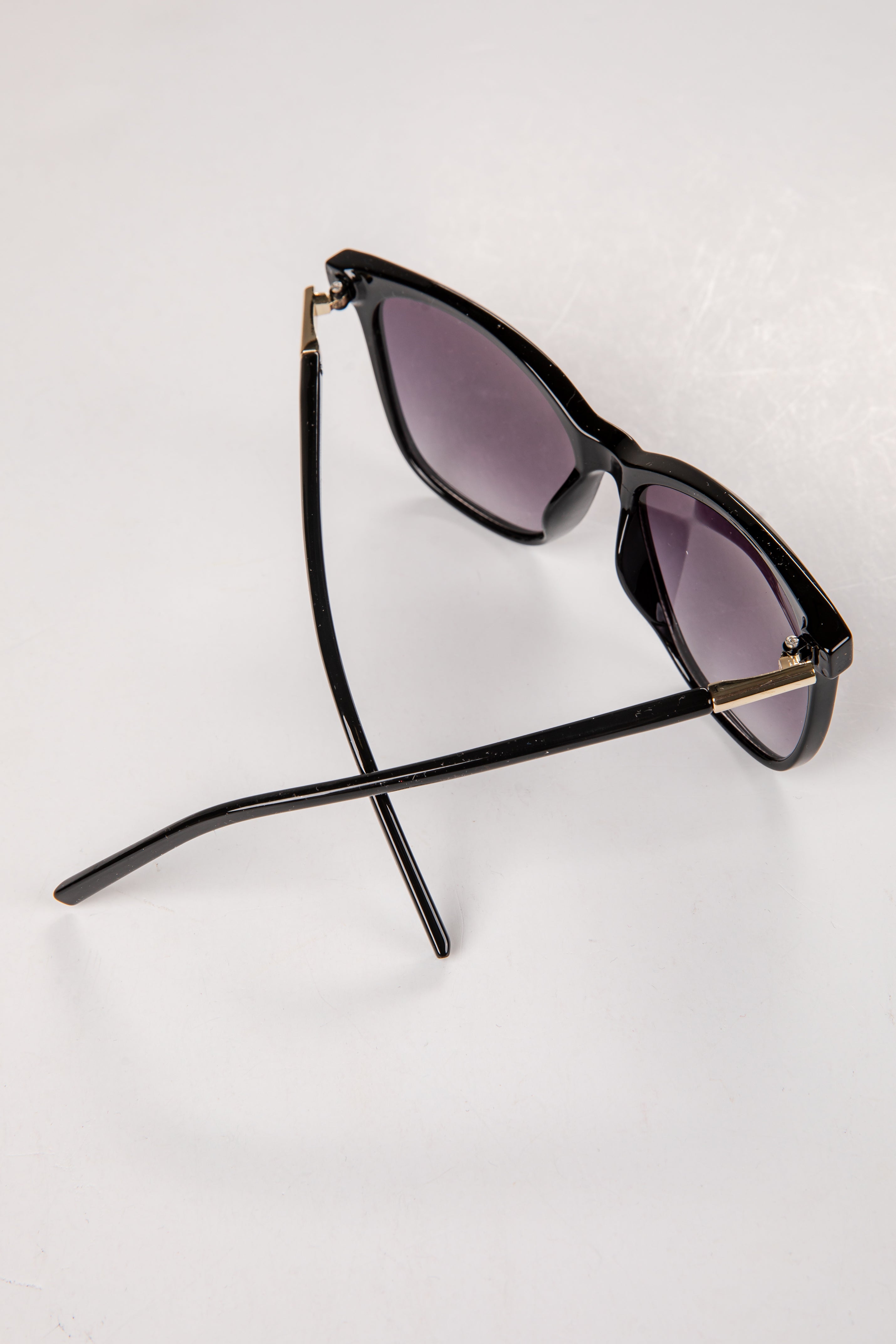 Black sunglasses with purple lenses on a white background
