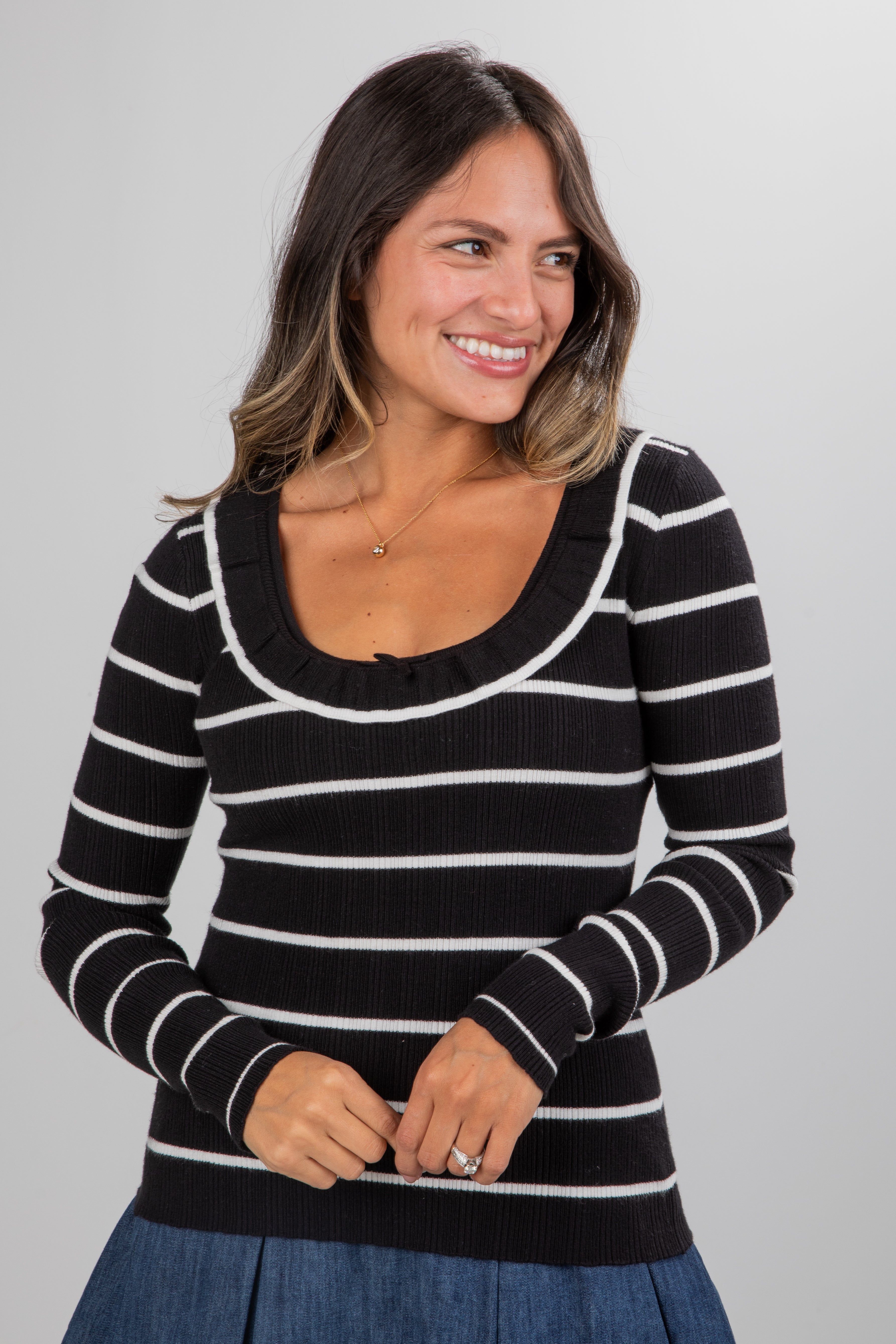 Woman wearing a black and white striped sweater against a gray background