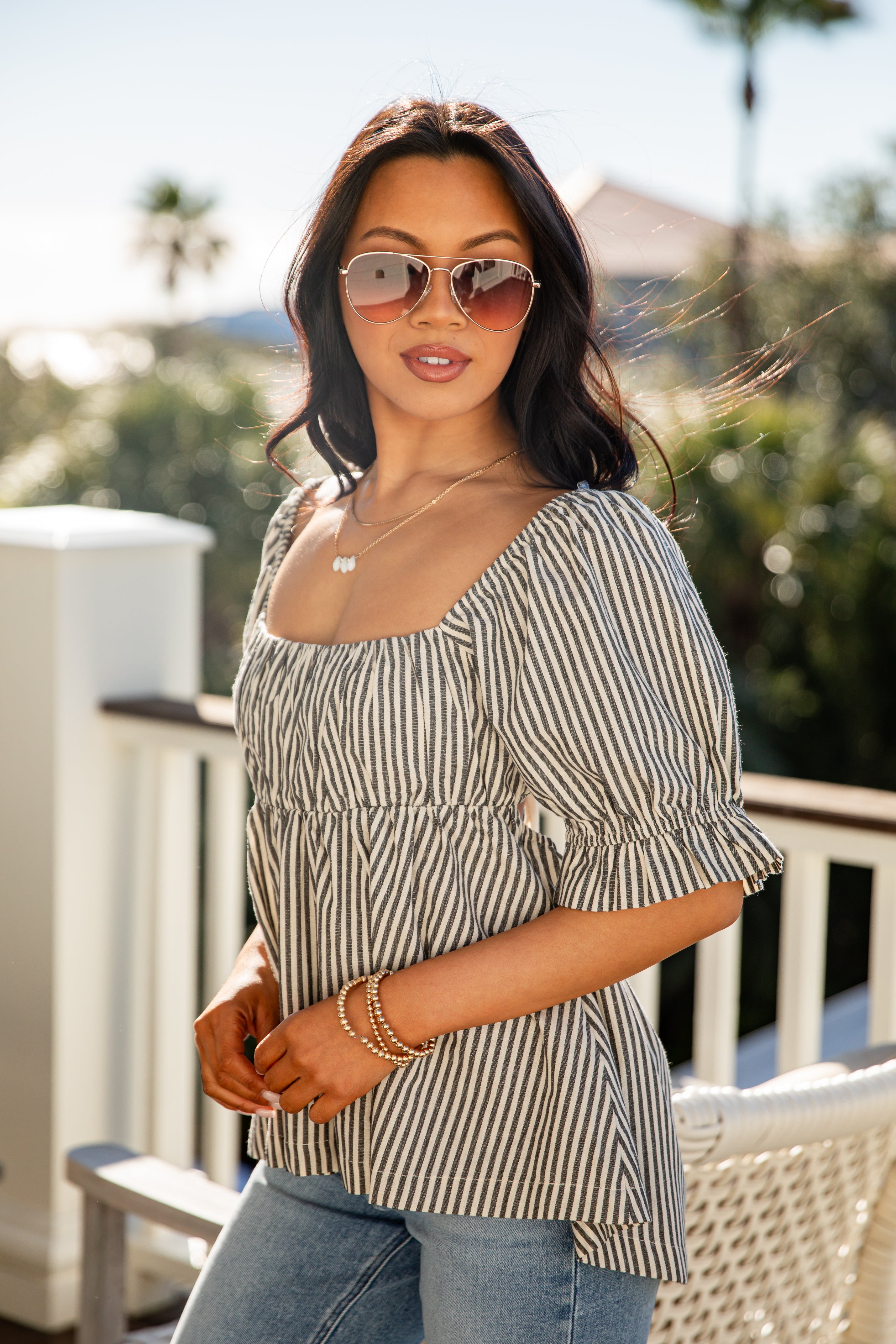 Woman wearing a striped top and sunglasses outdoors