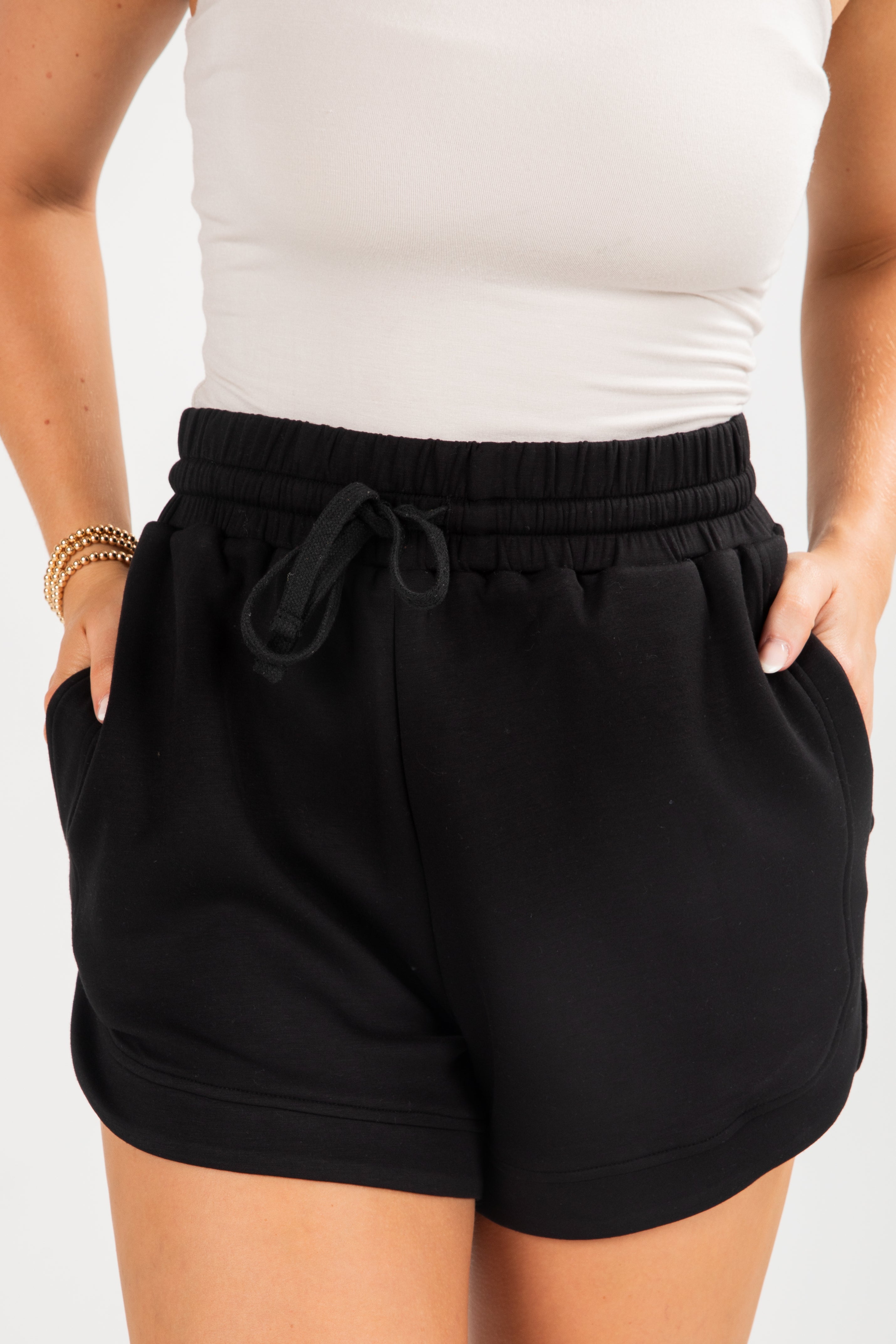 Black shorts worn by a person on a white background