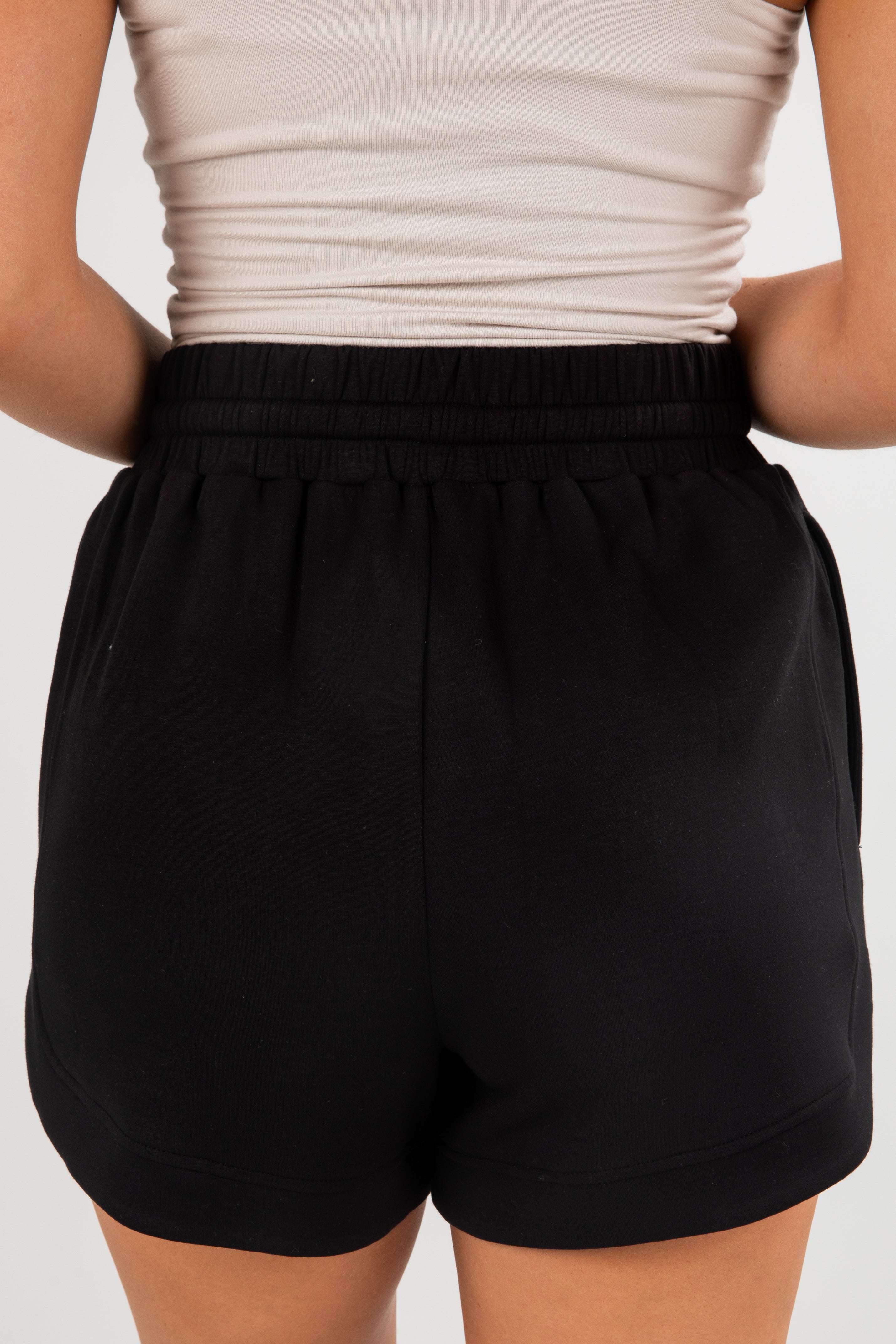 Black shorts worn by a person on a plain background