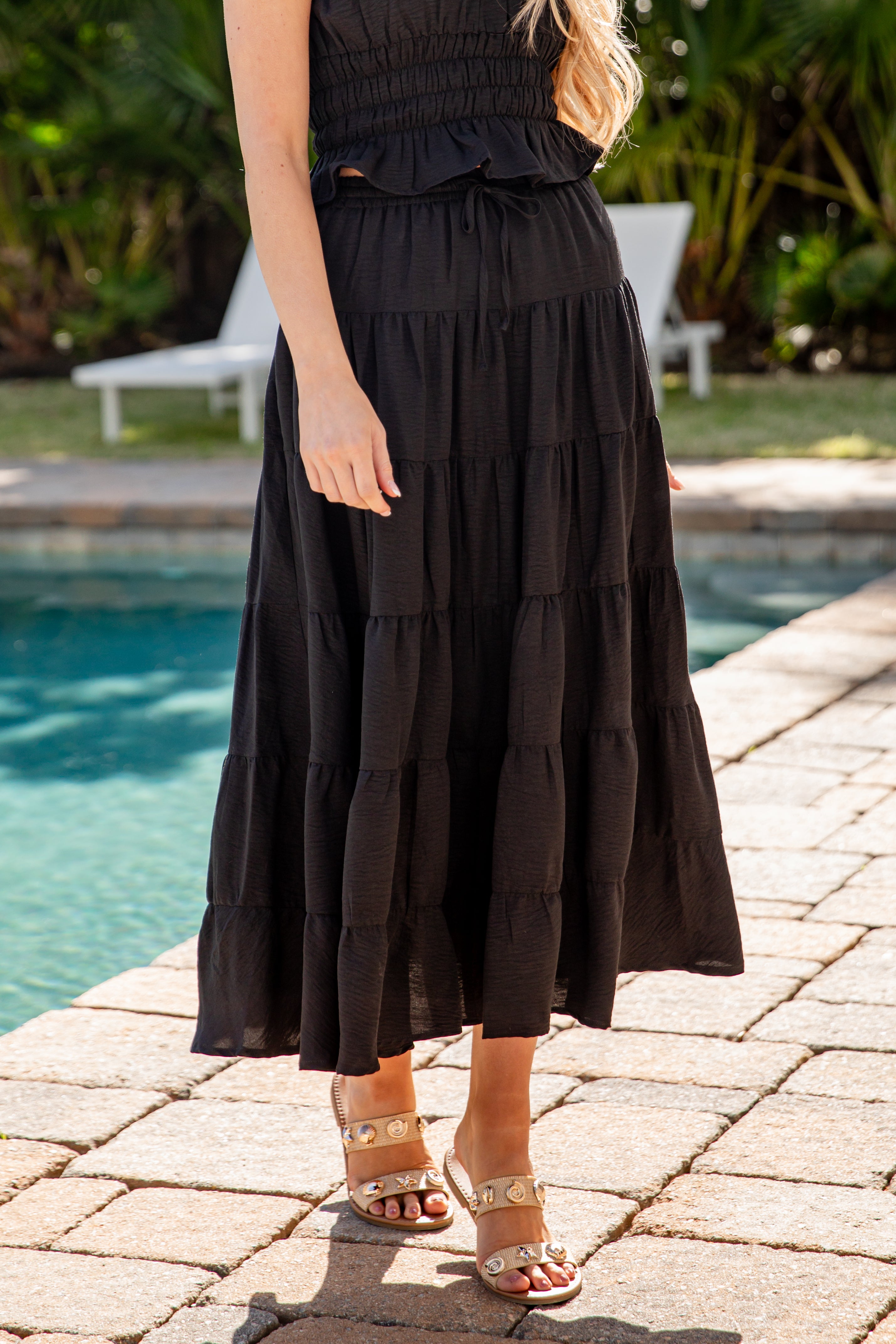 Woman wearing a black dress by a poolside