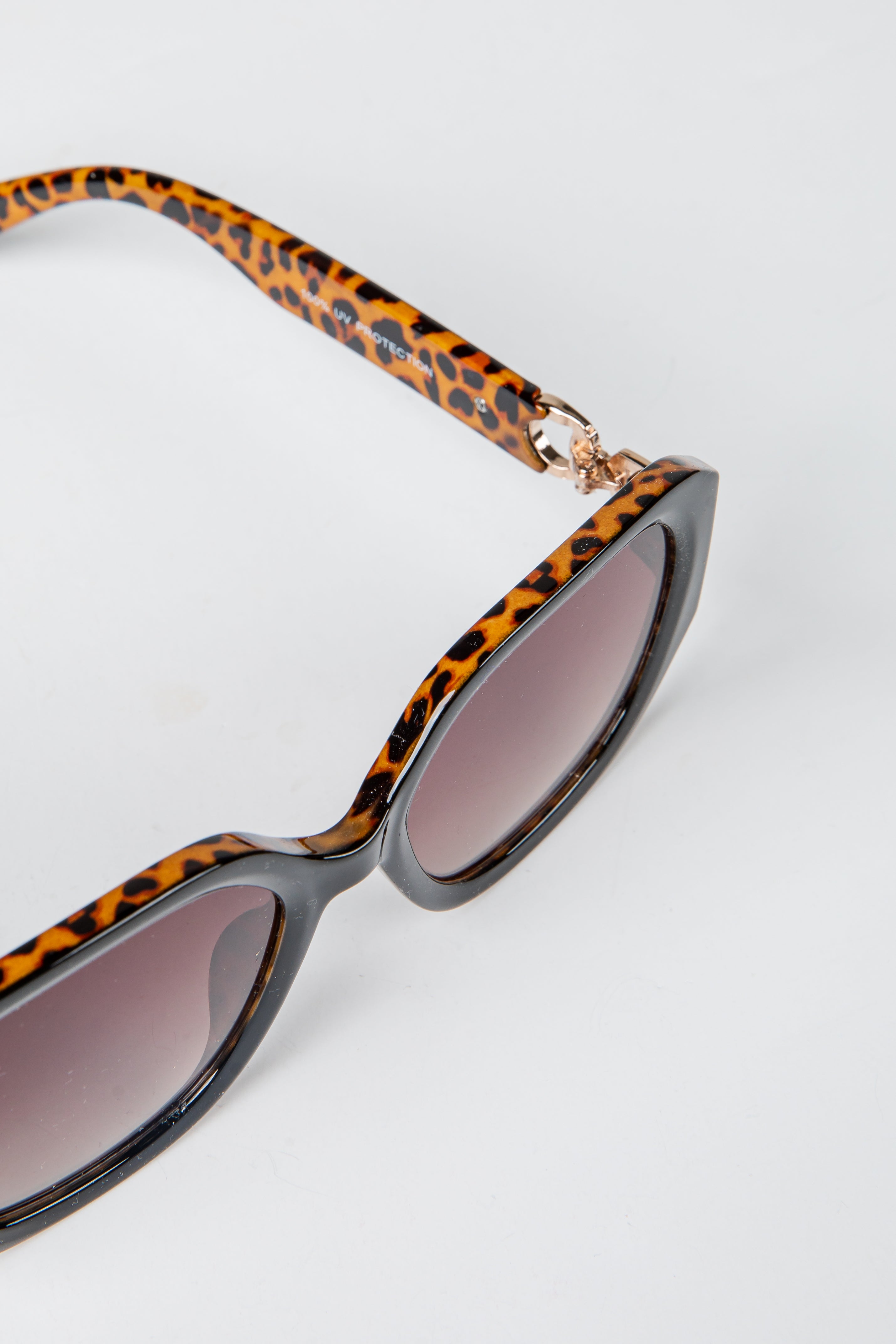 Sunglasses with leopard print frame and gray lenses on a white background