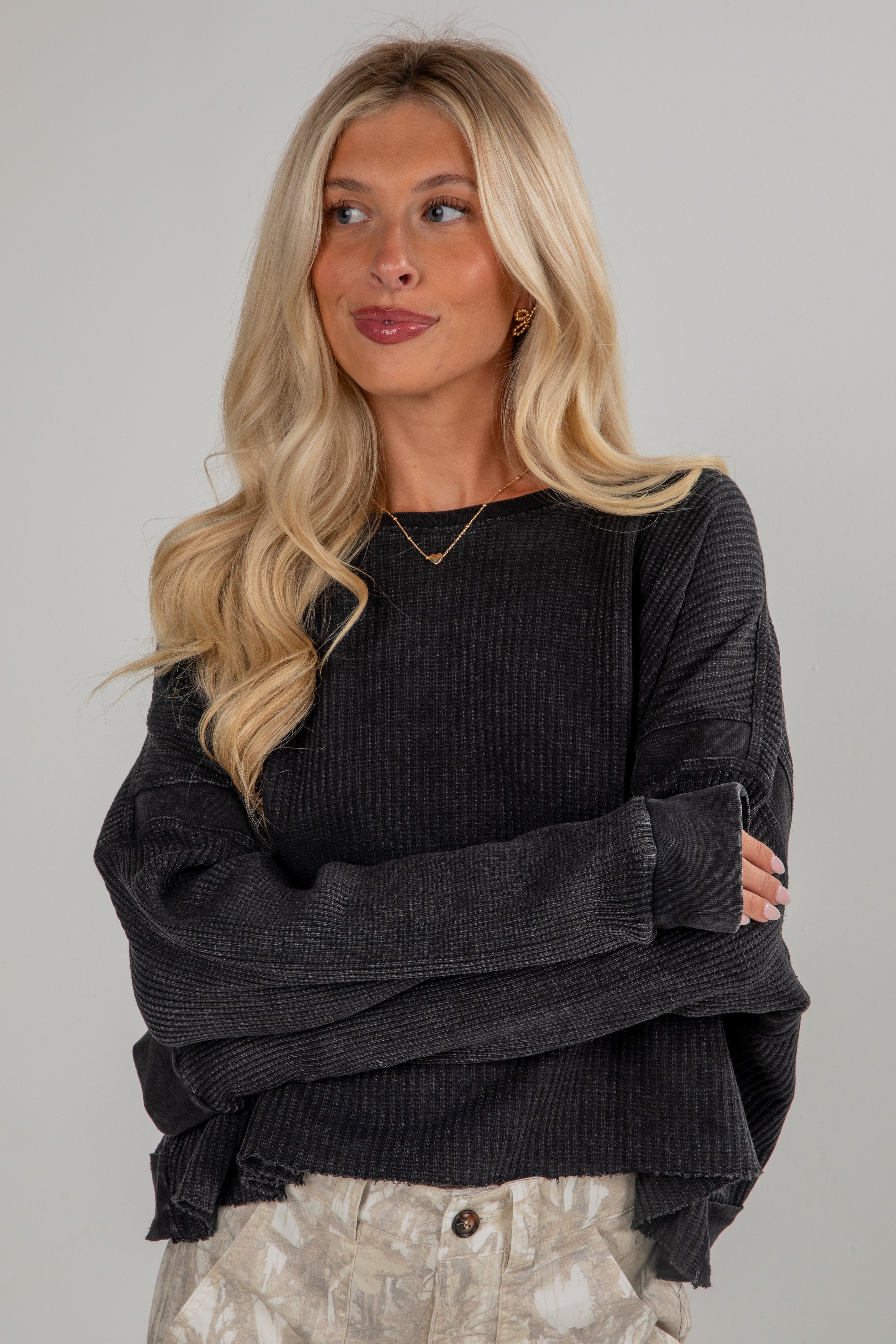Woman wearing a dark gray sweater against a plain background