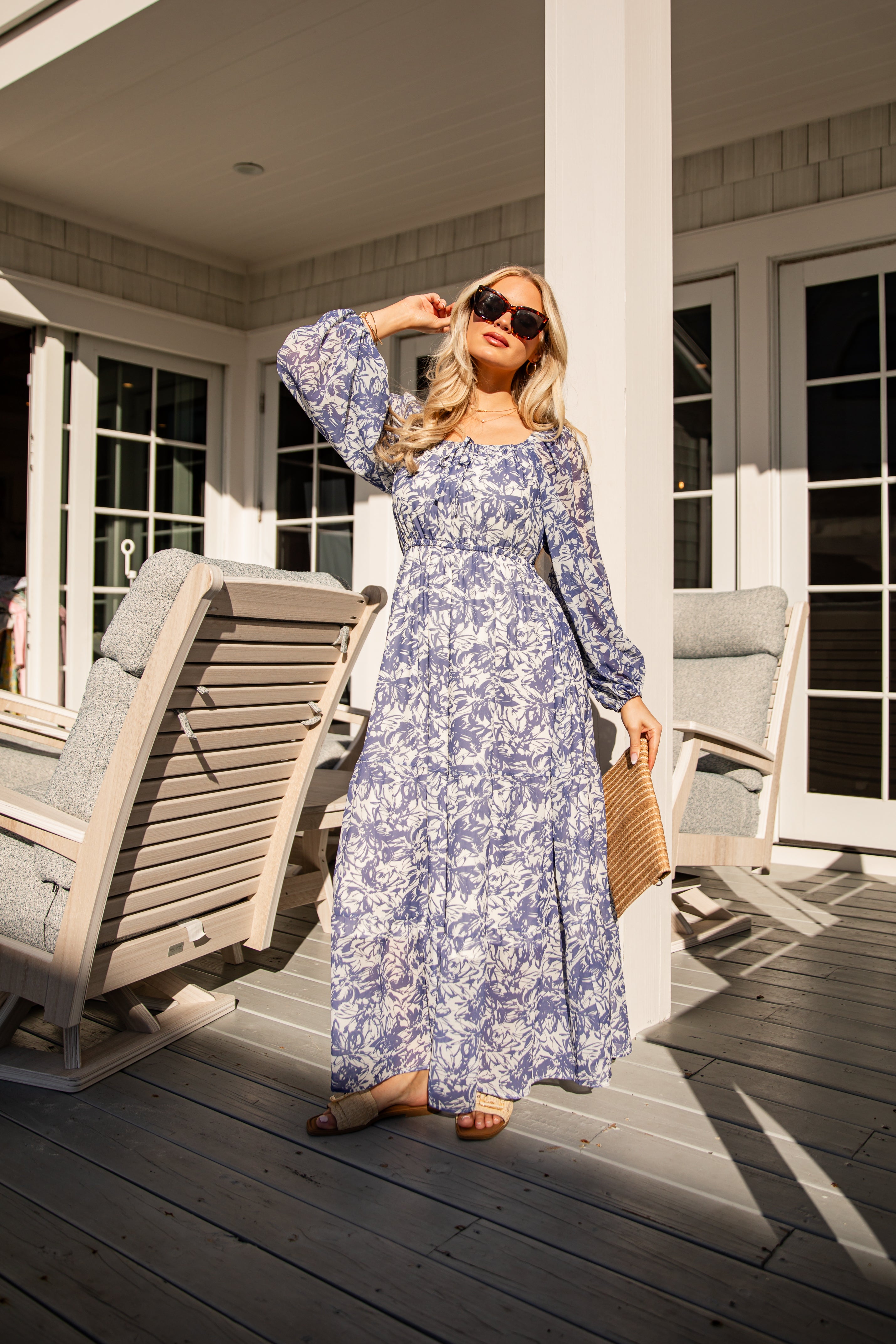 Woman in a floral dress standing on a wooden deck