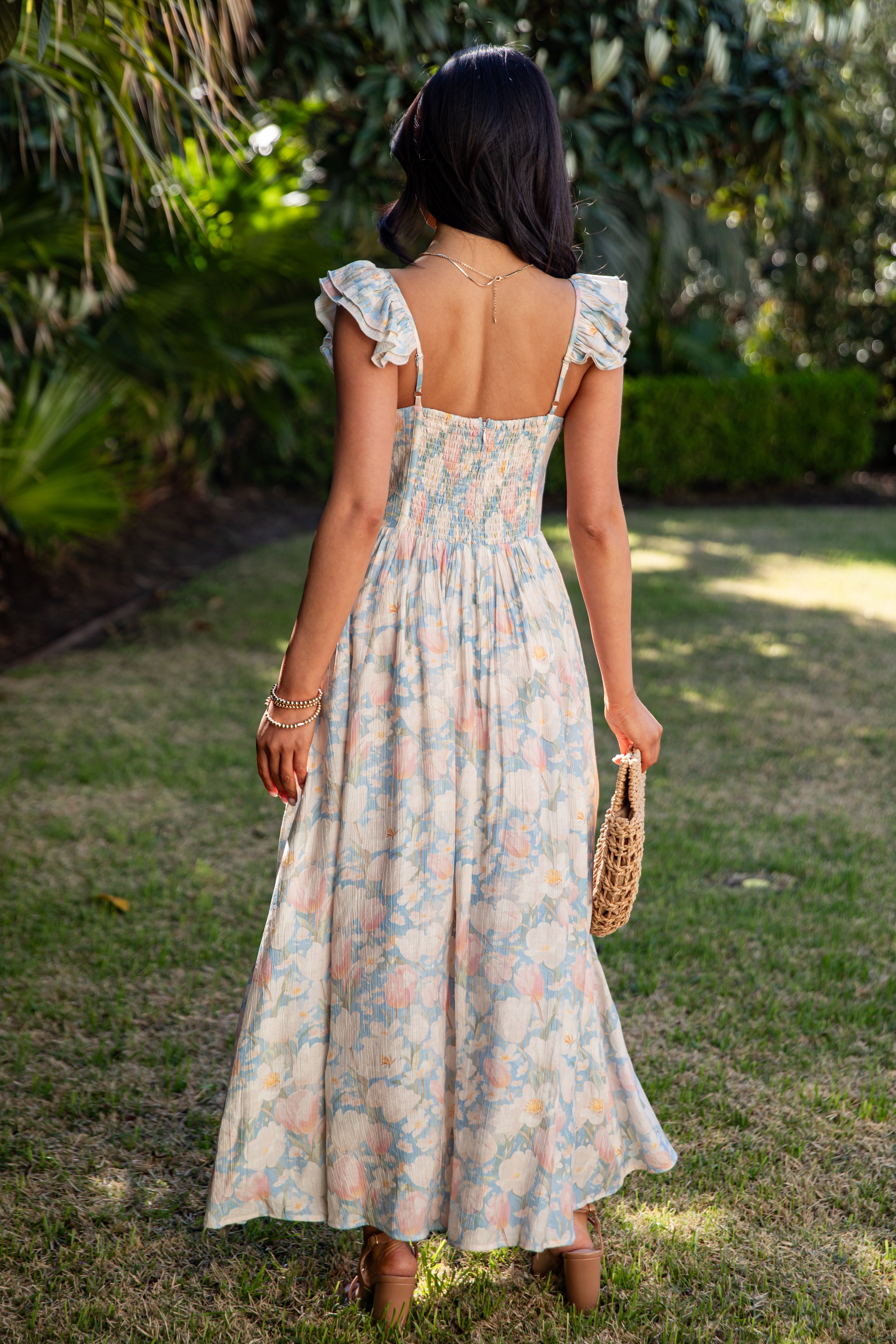 Woman in a floral dress standing in a garden