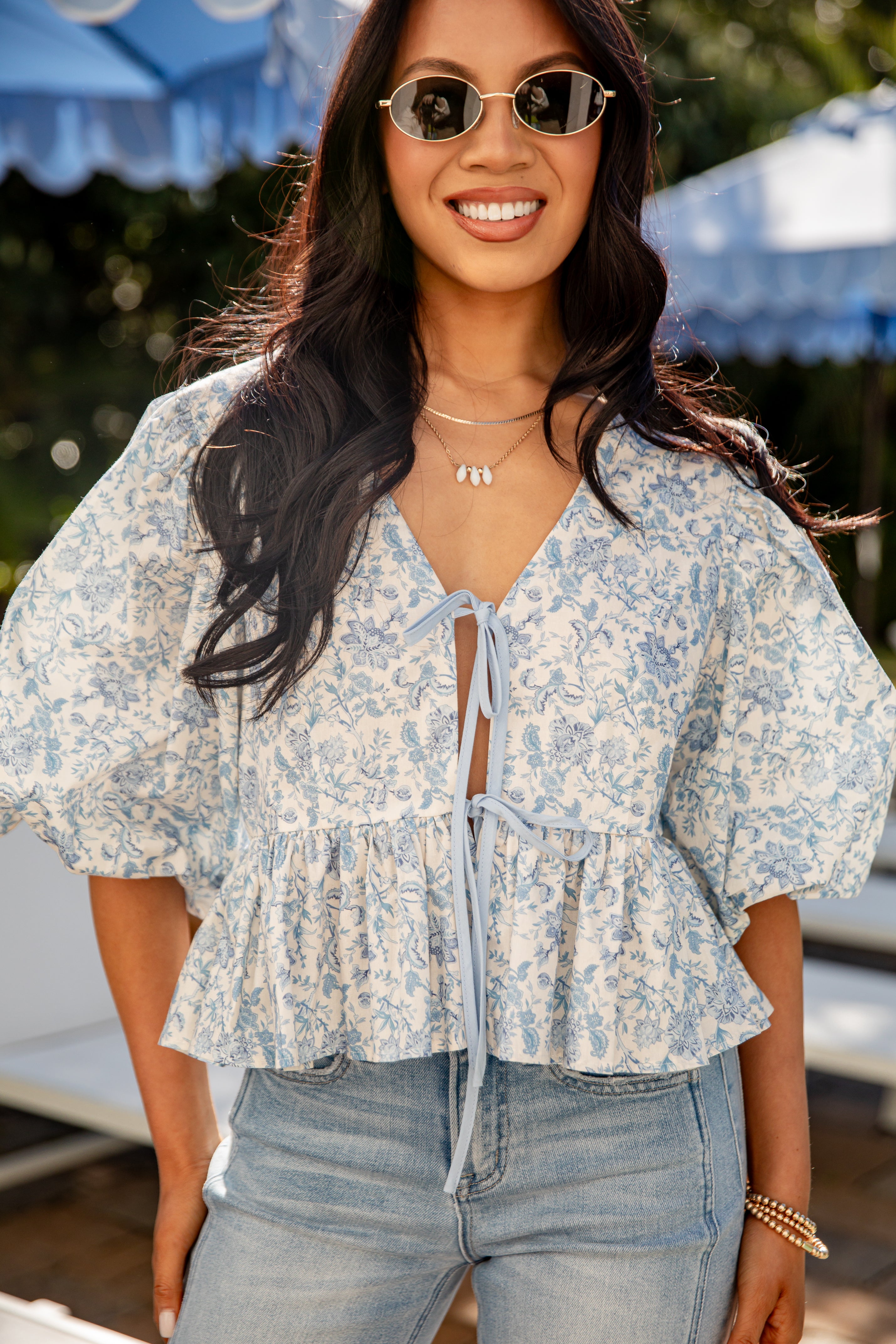 Woman wearing a floral blouse and sunglasses outdoors