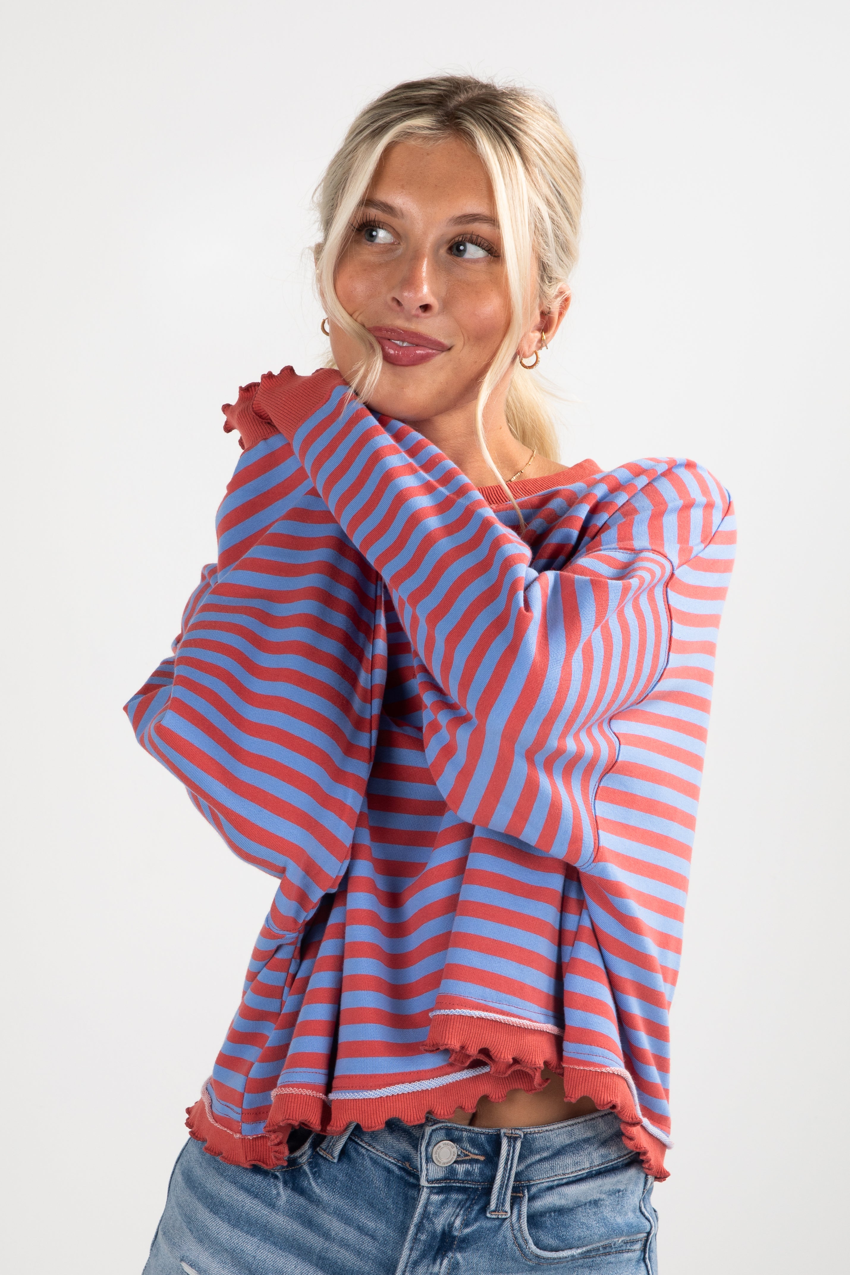 Woman wearing a red and blue striped sweater against a white background