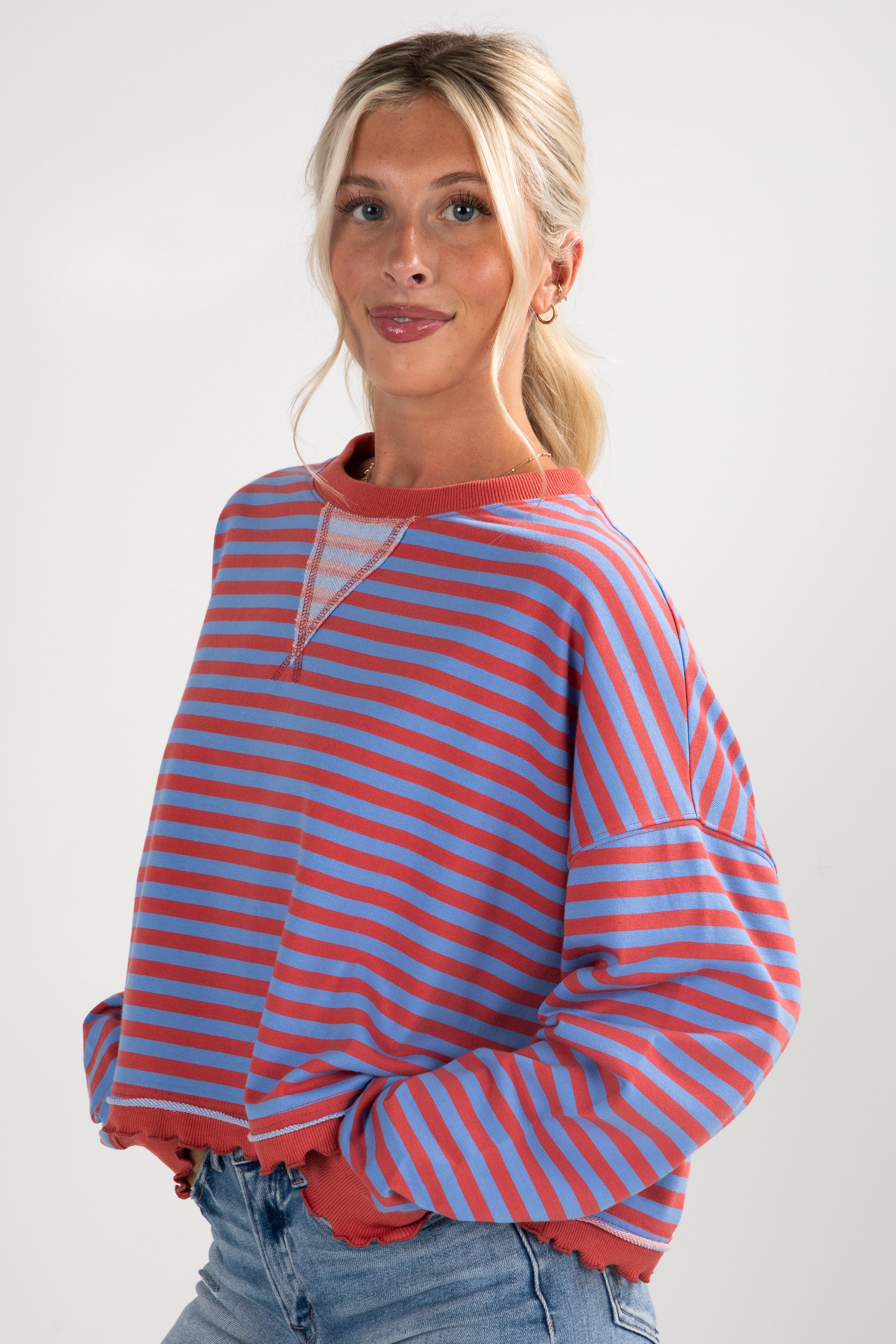 Woman wearing a red and blue striped sweater against a white background