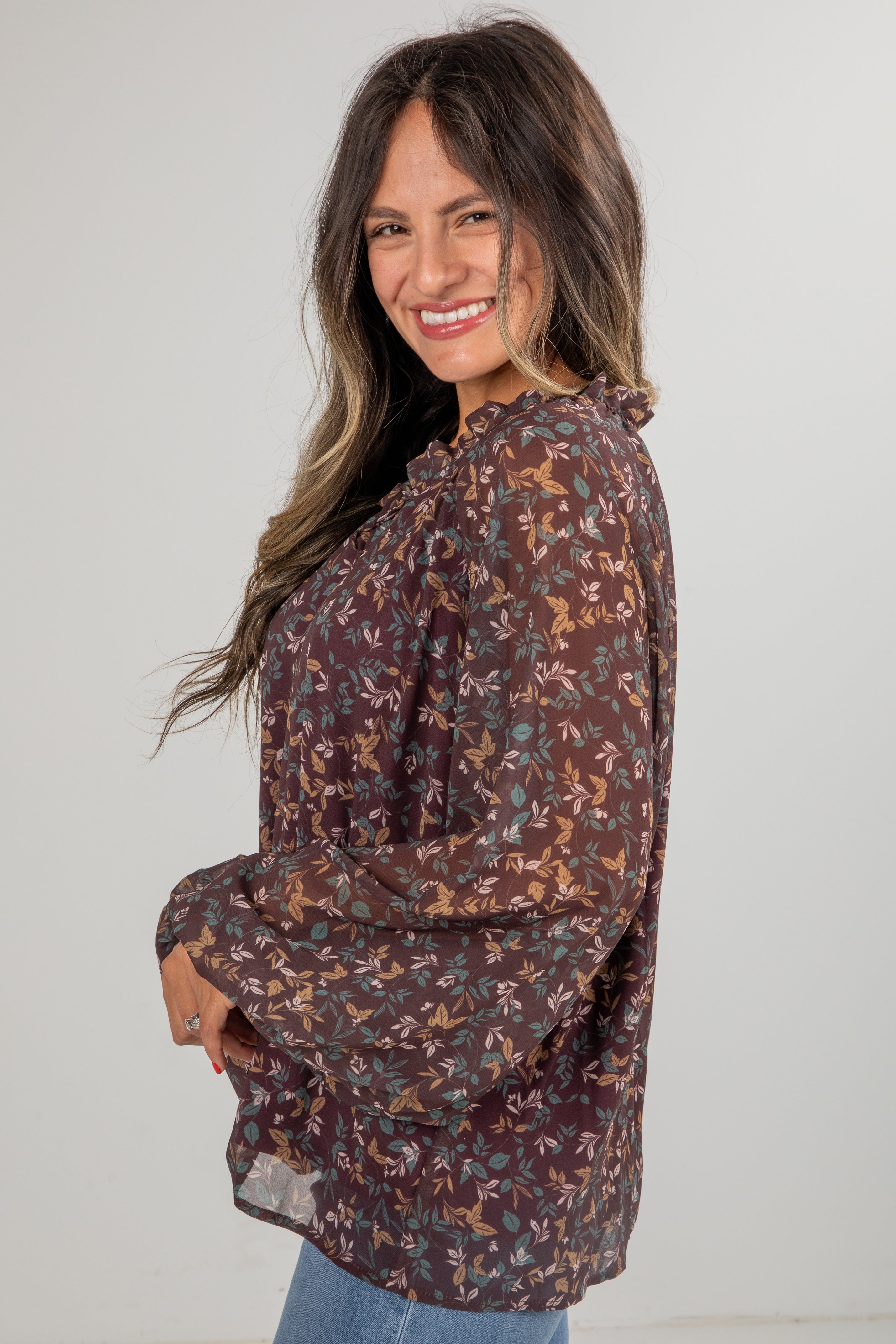 Woman wearing a floral blouse with a plain background