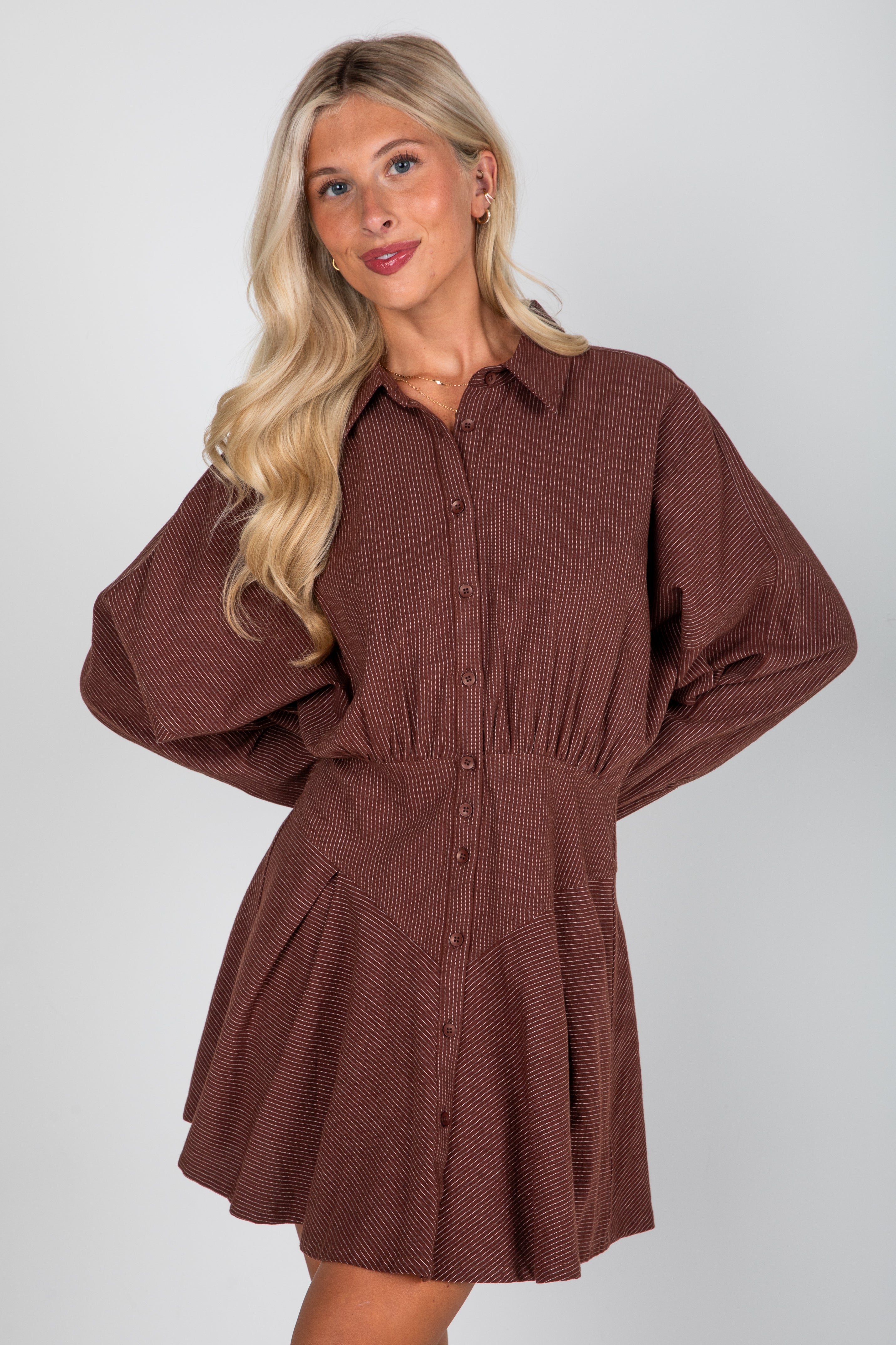 Woman wearing a brown dress against a white background