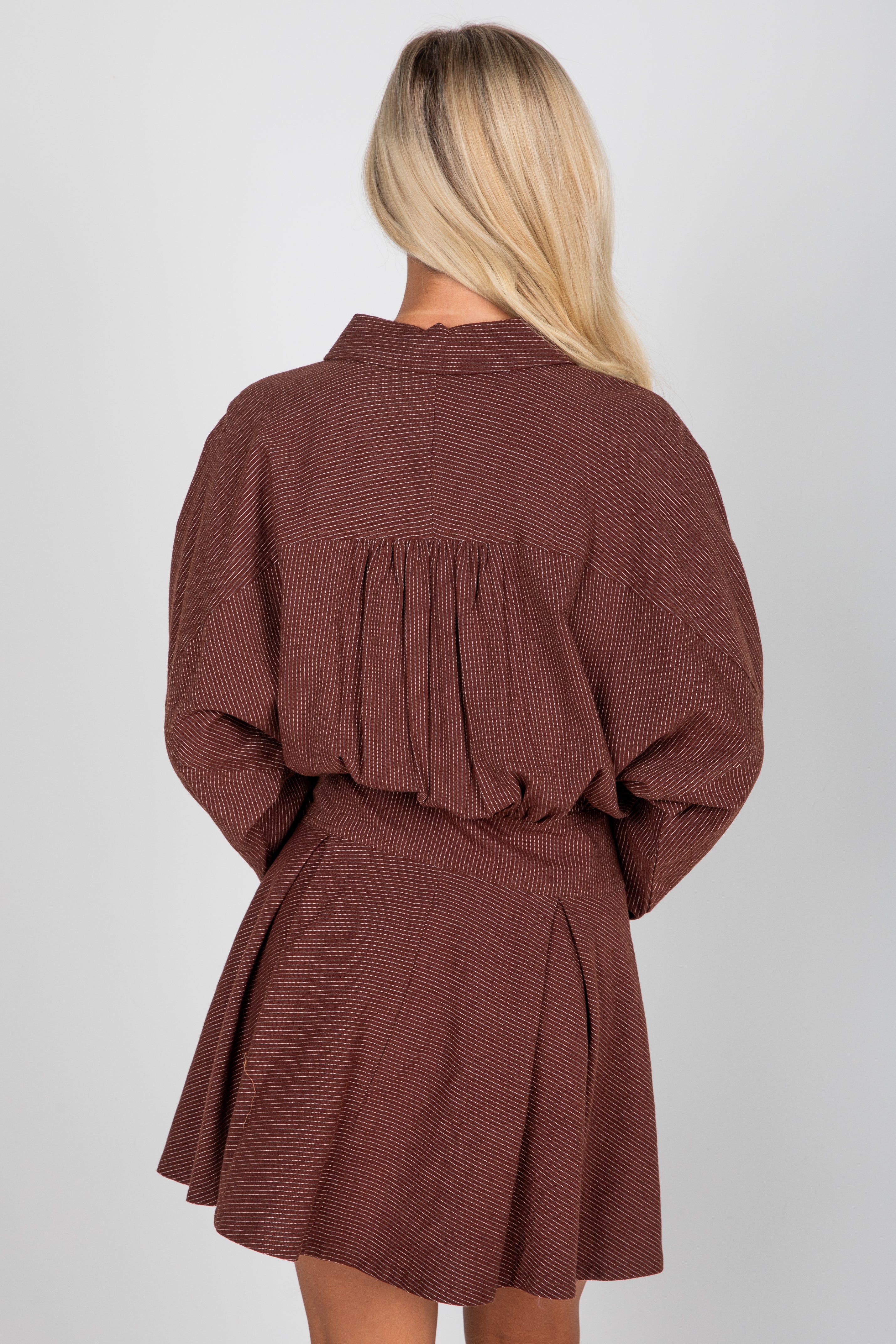 Brown textured dress worn by a person on a white background