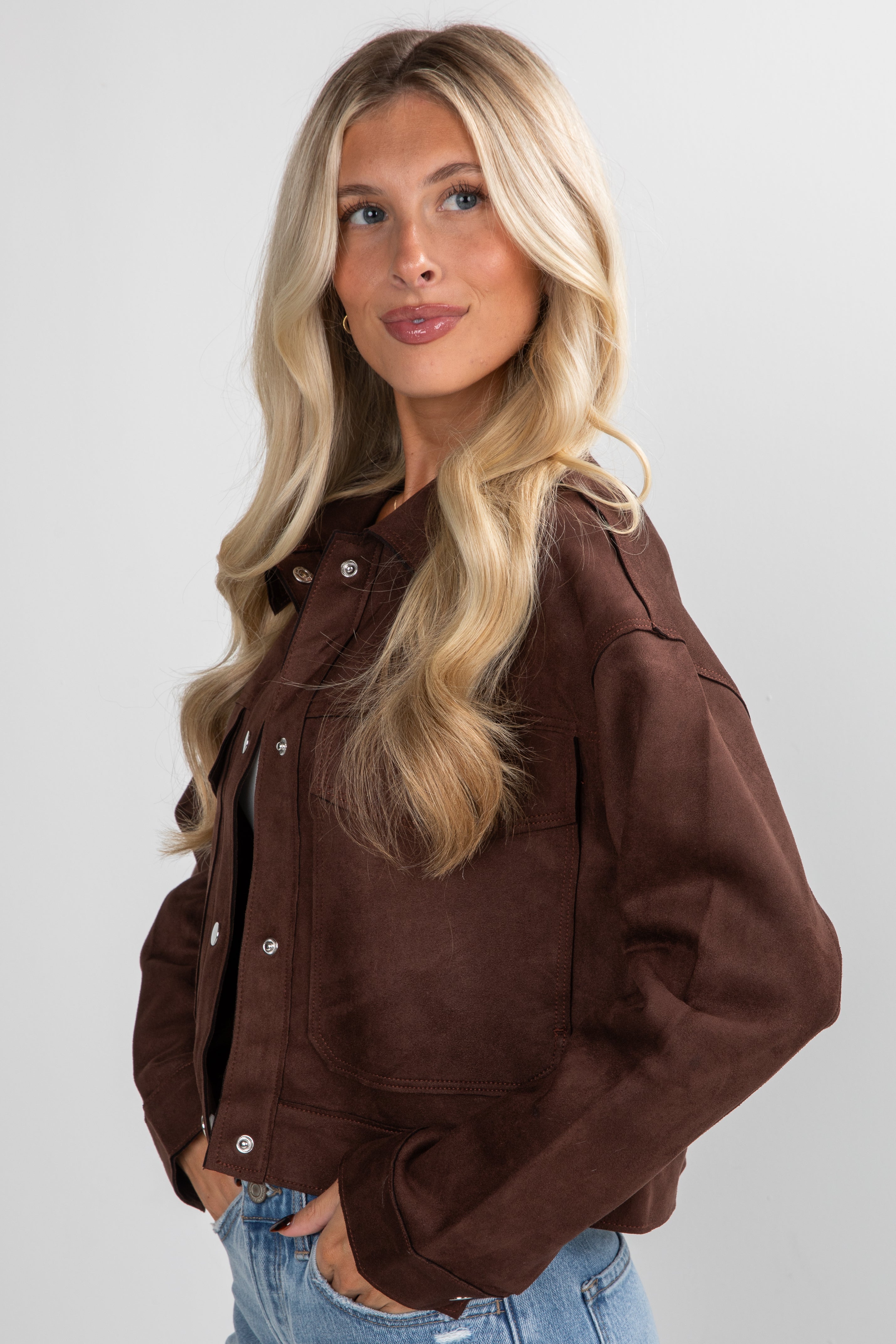 Woman wearing a brown jacket on a plain background