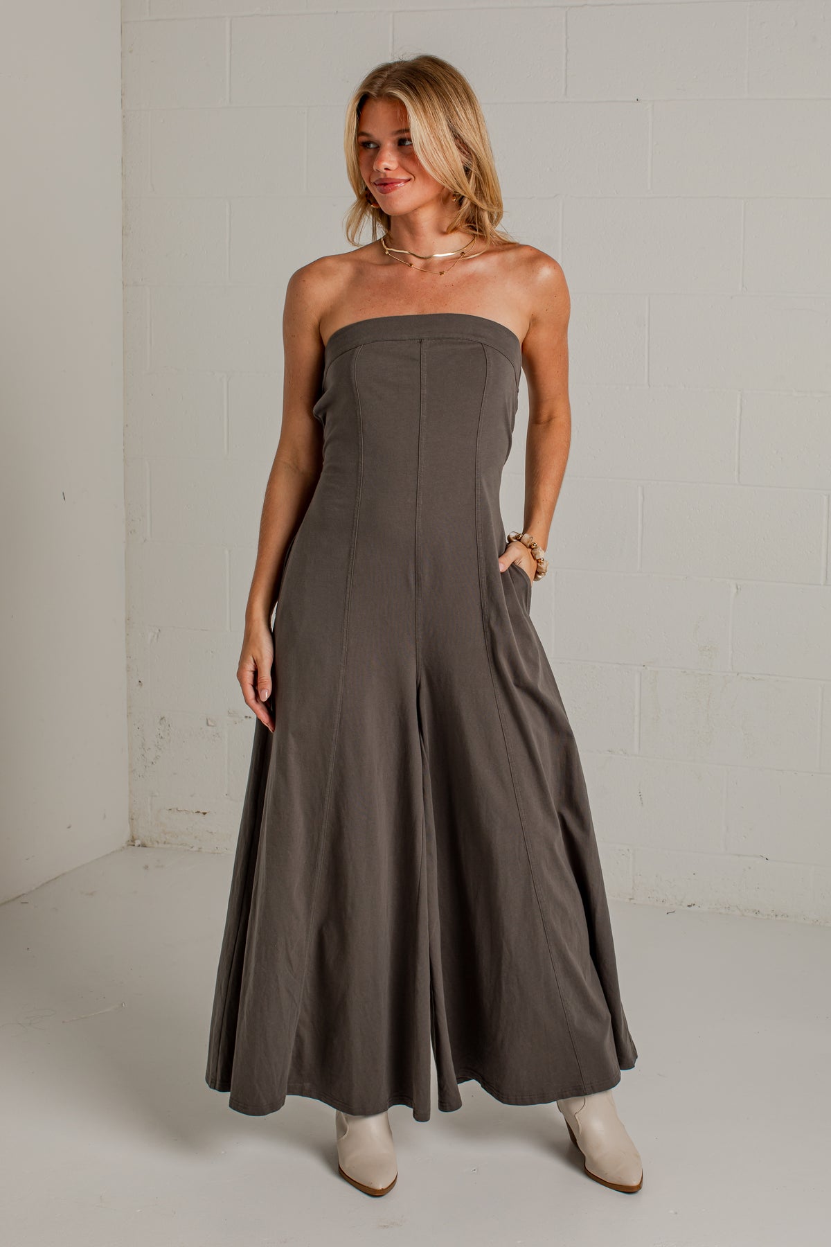A dark gray strapless wide-leg jumpsuit with side pockets