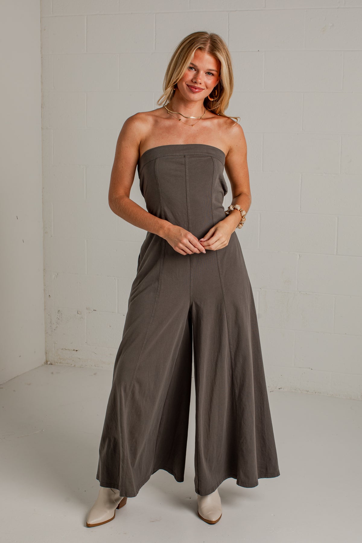 A dark gray strapless wide-leg jumpsuit with side pockets