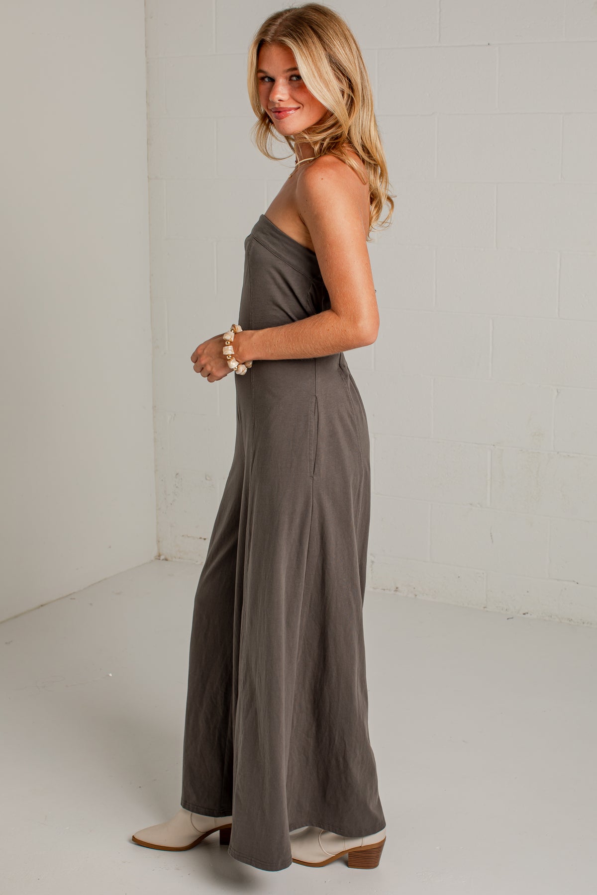 A dark gray strapless wide-leg jumpsuit with side pockets