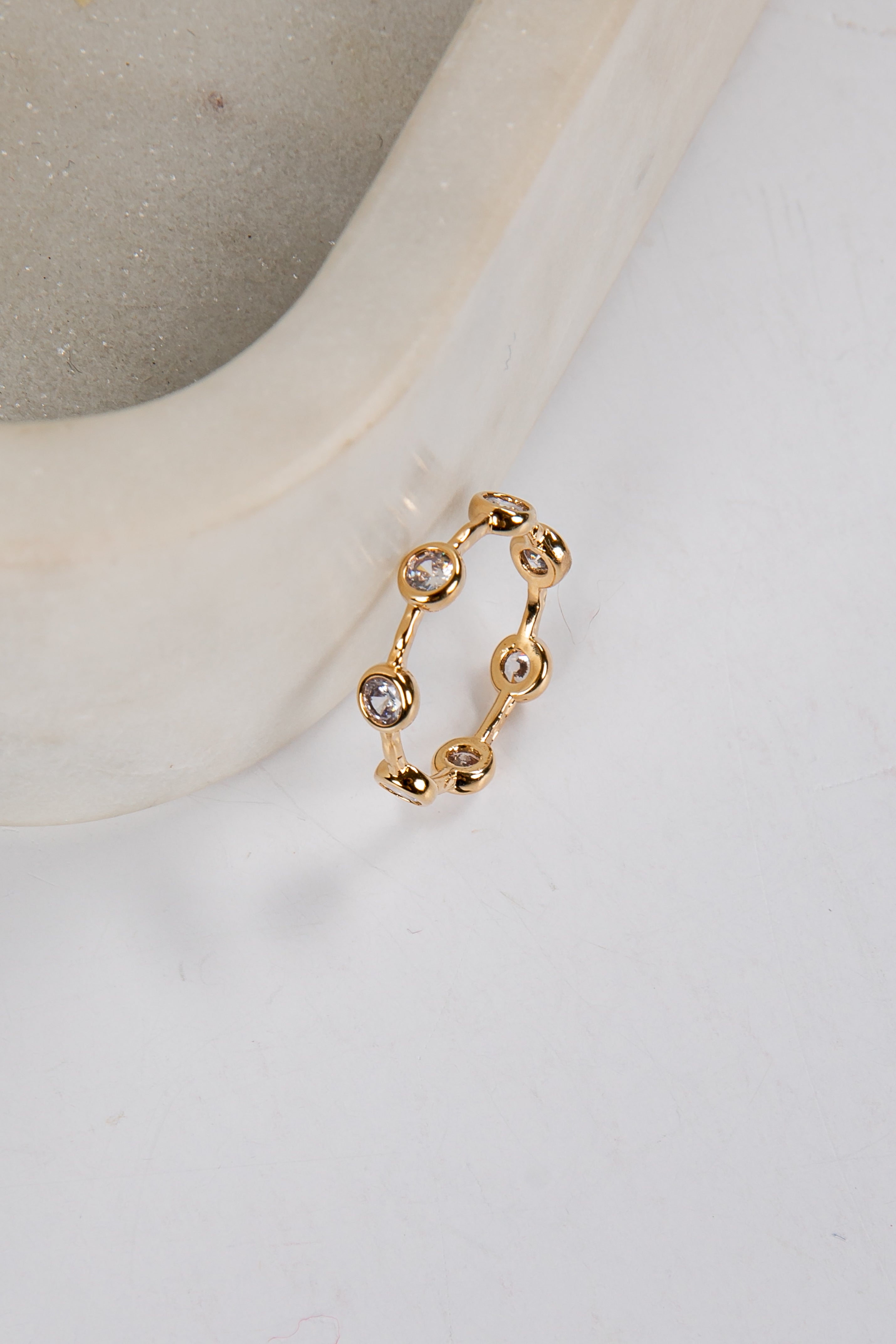 Gold ring with small stones on a white surface