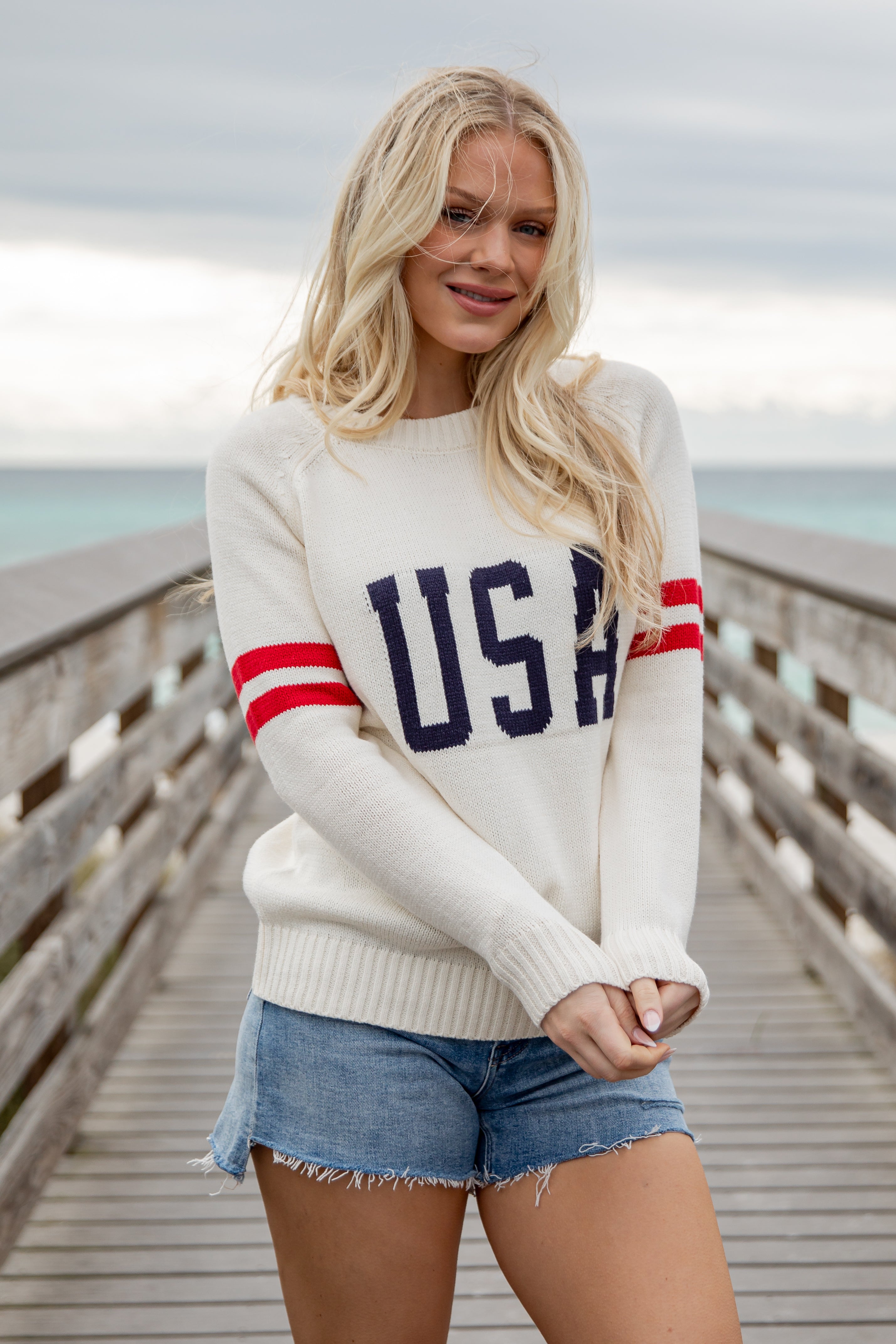 Woman wearing a white sweater with &