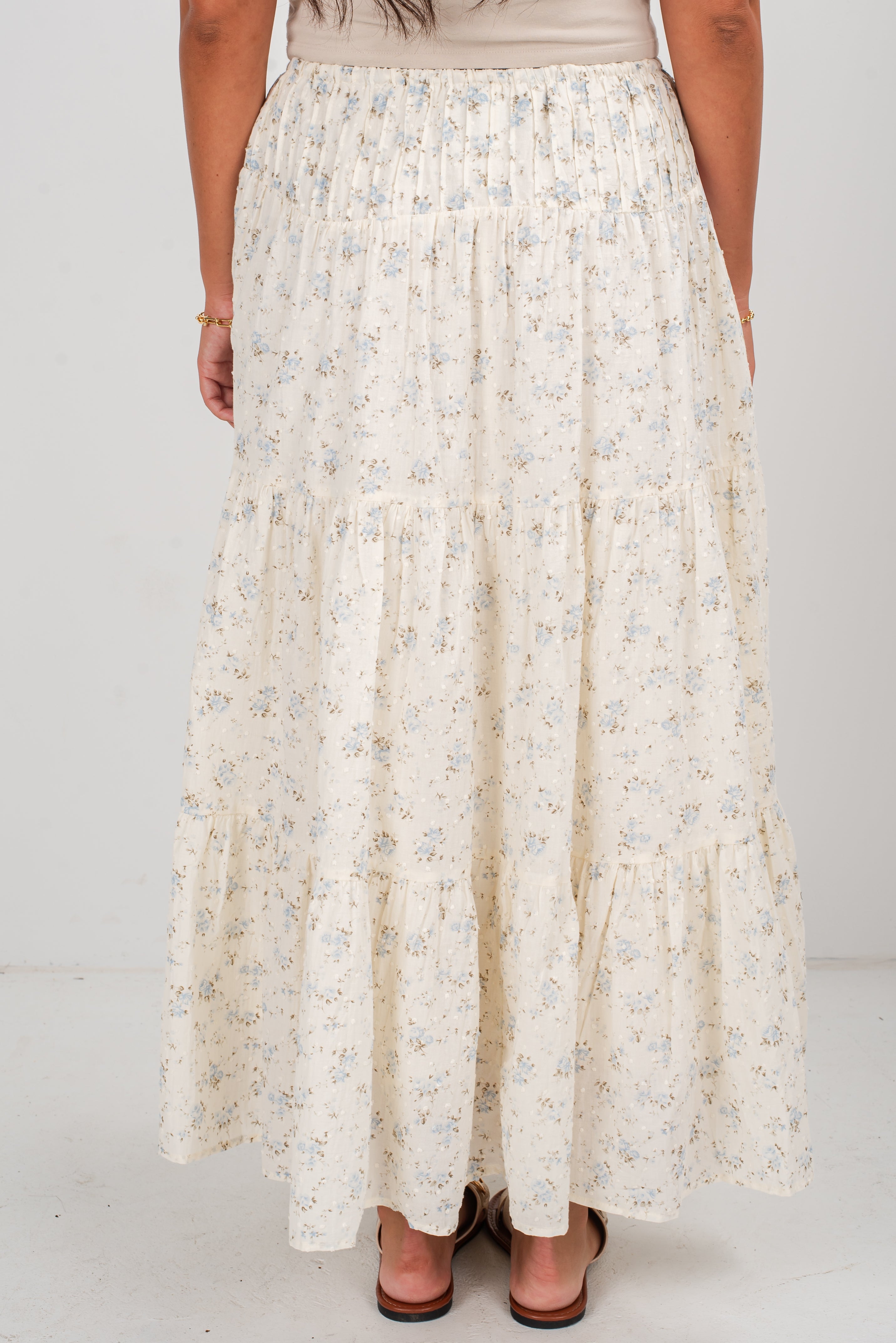 Long floral skirt worn by a person on a white background
