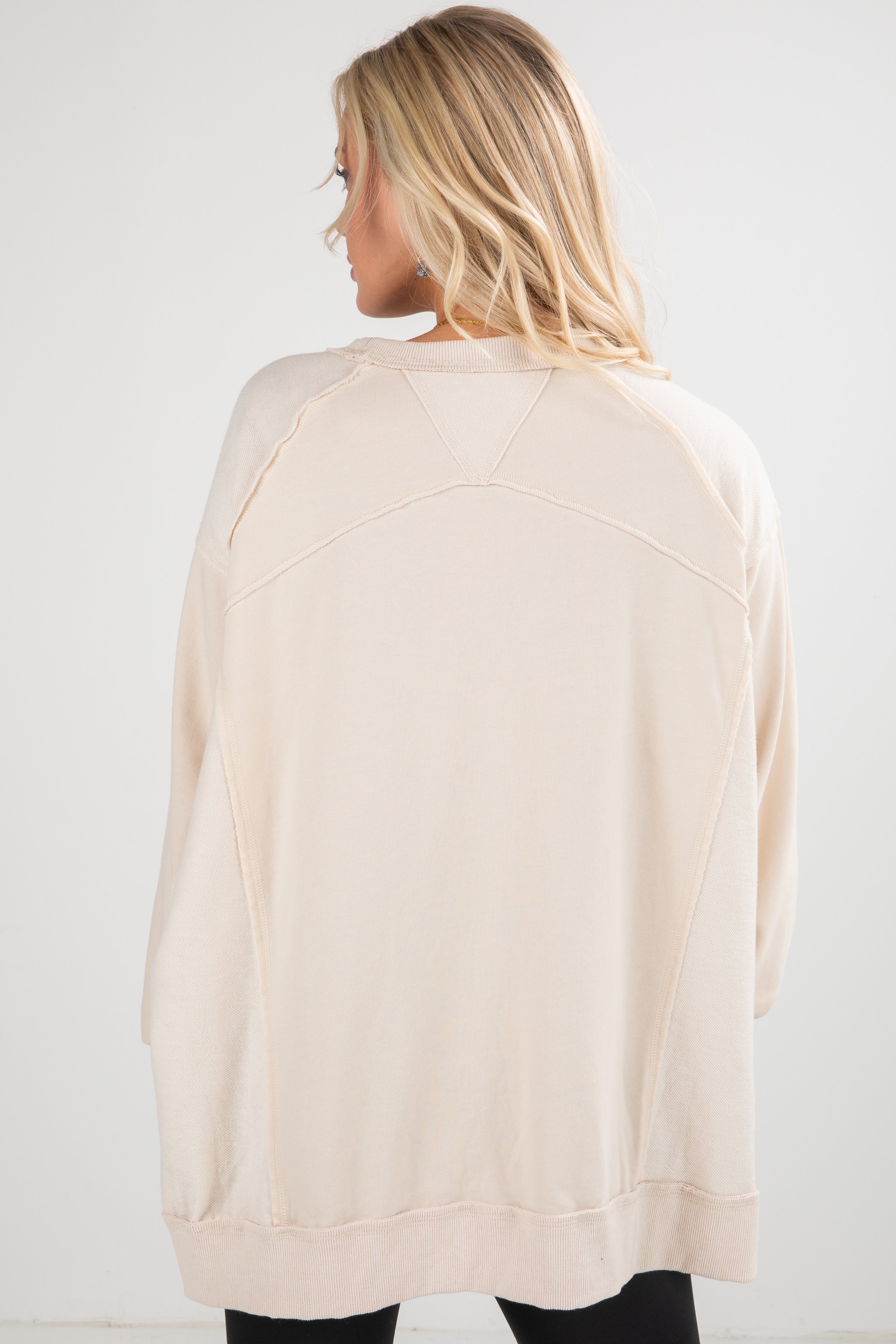 Woman wearing a beige cardigan against a white background