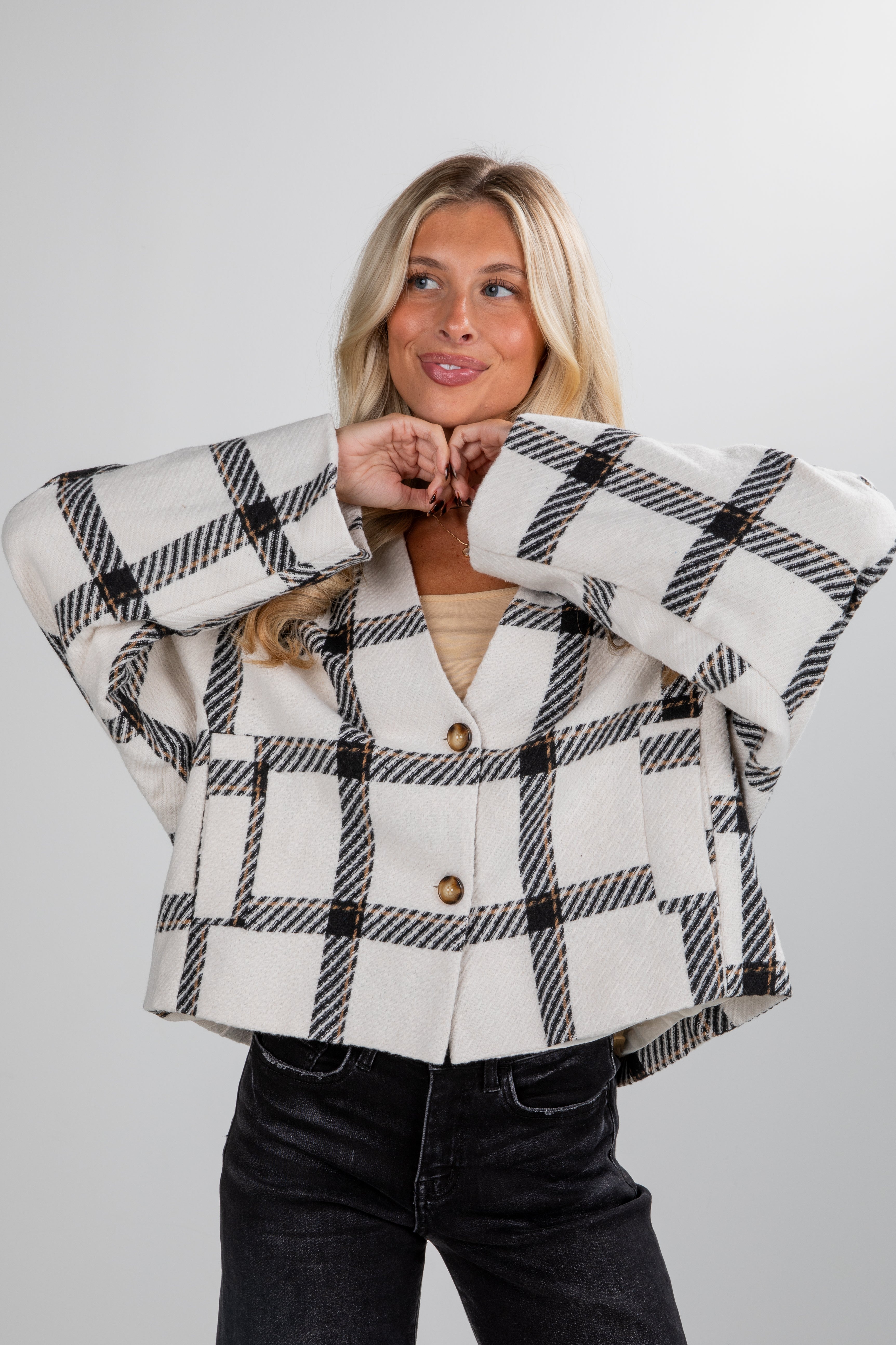Woman wearing a plaid jacket with a plain background