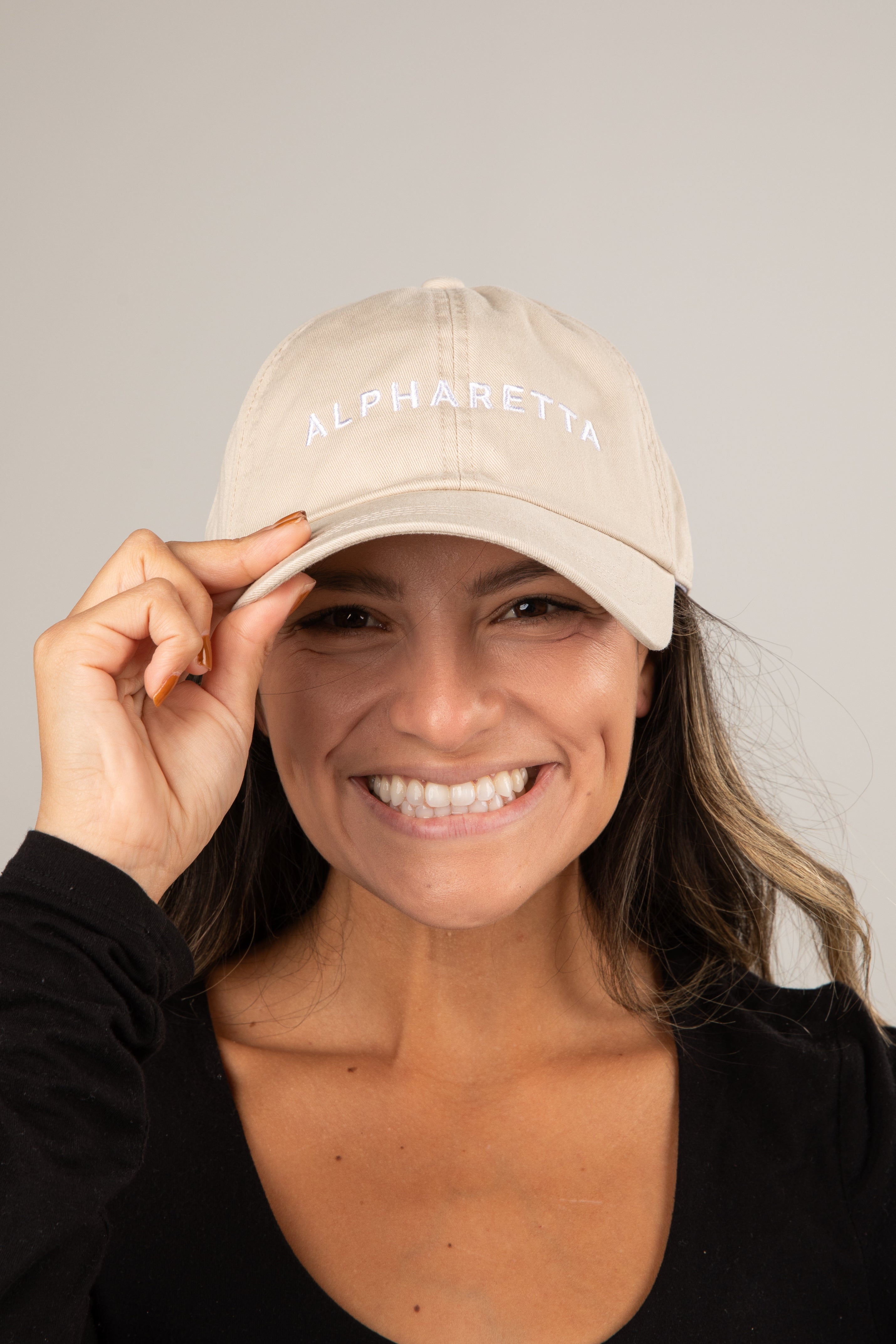 Woman wearing a beige cap with &