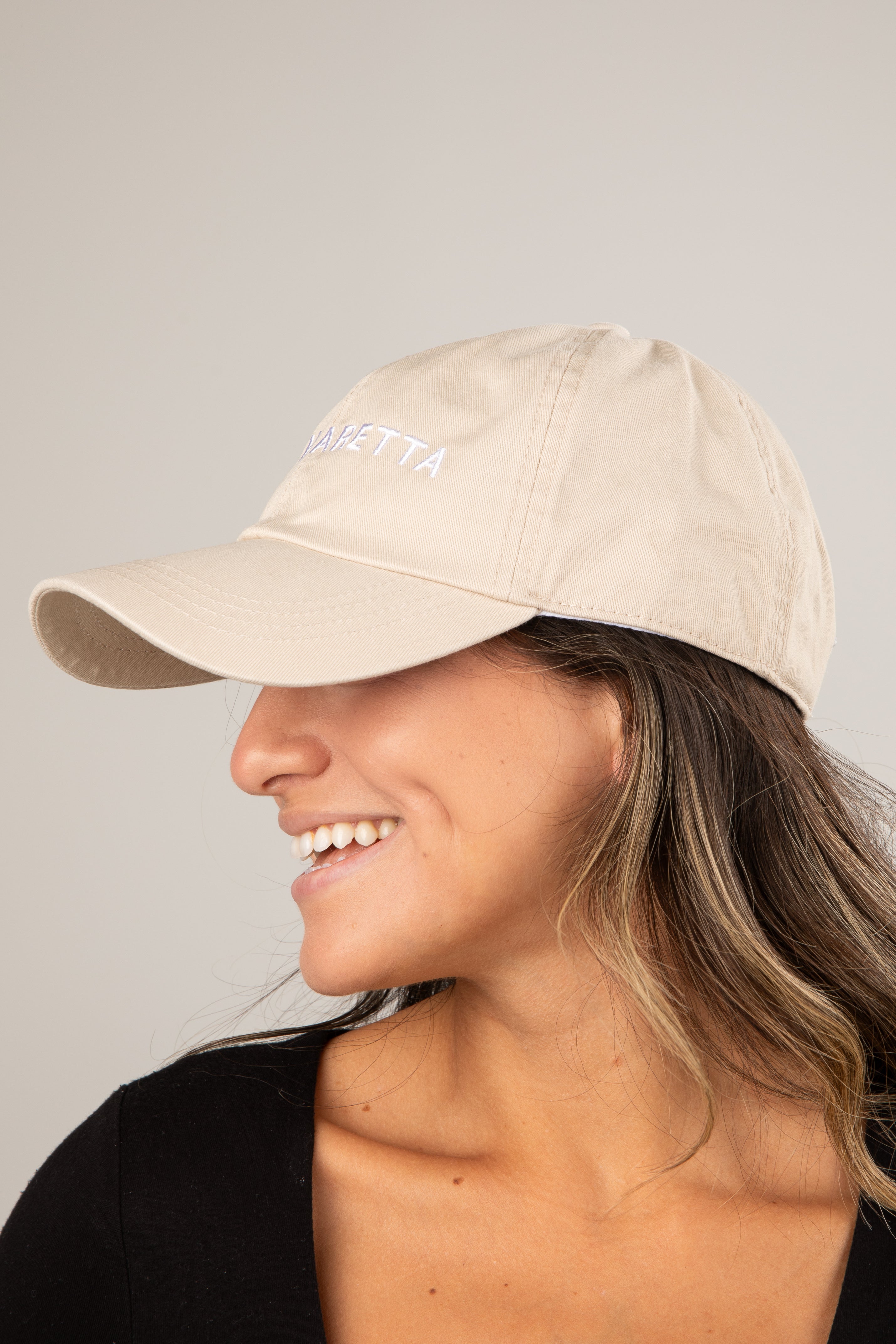 Woman wearing a beige cap with &