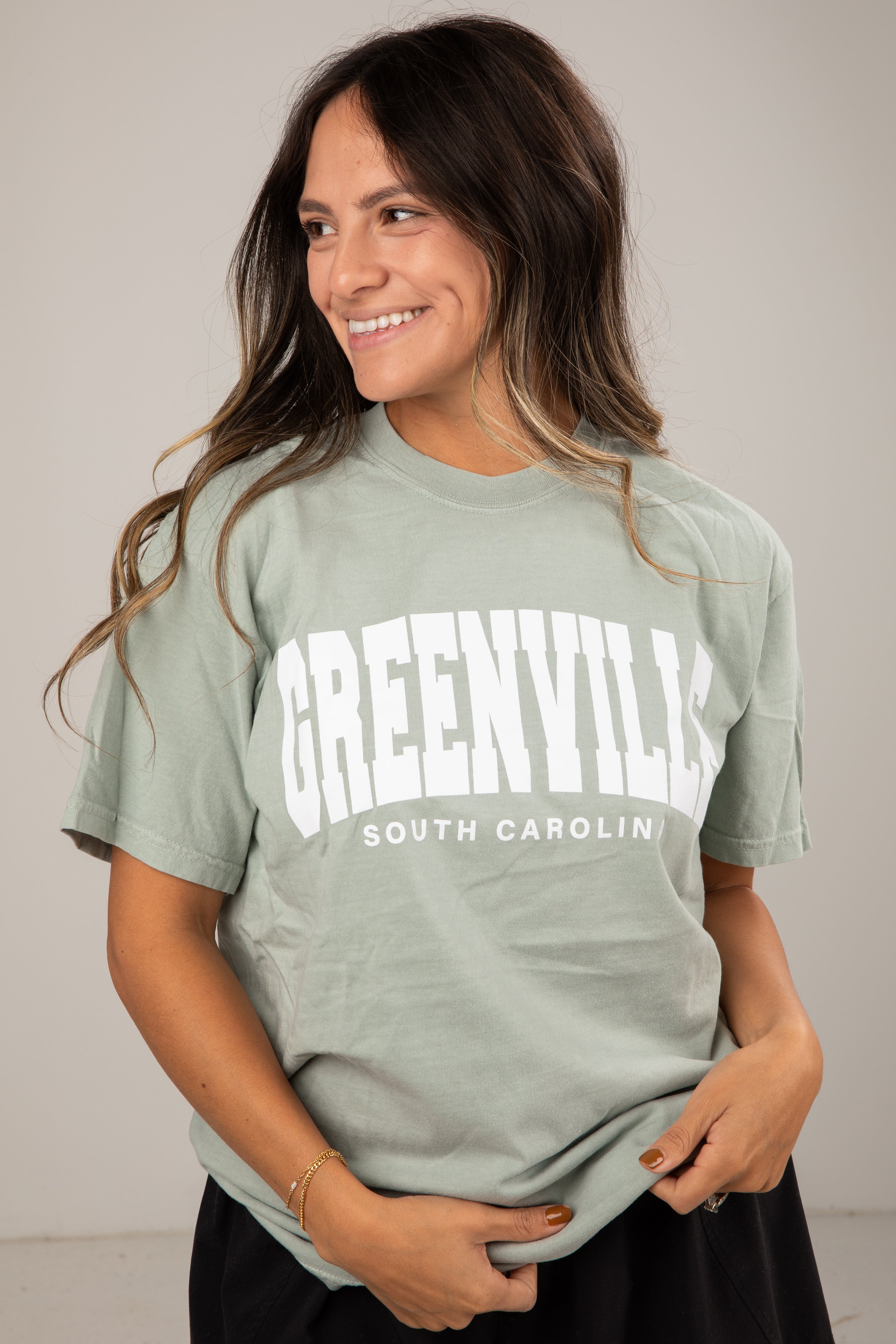 Woman wearing a green t-shirt with &