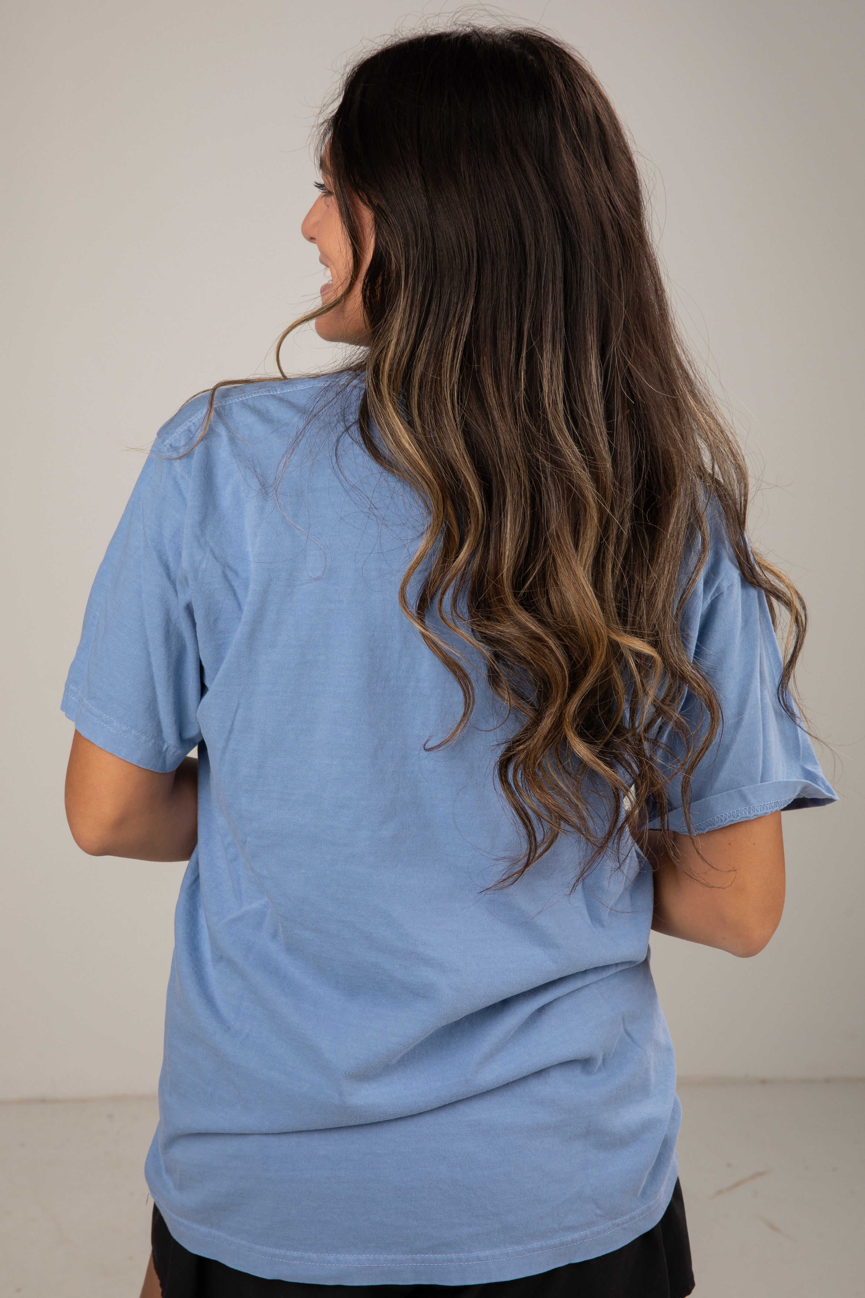 Person wearing a blue t-shirt with a plain background