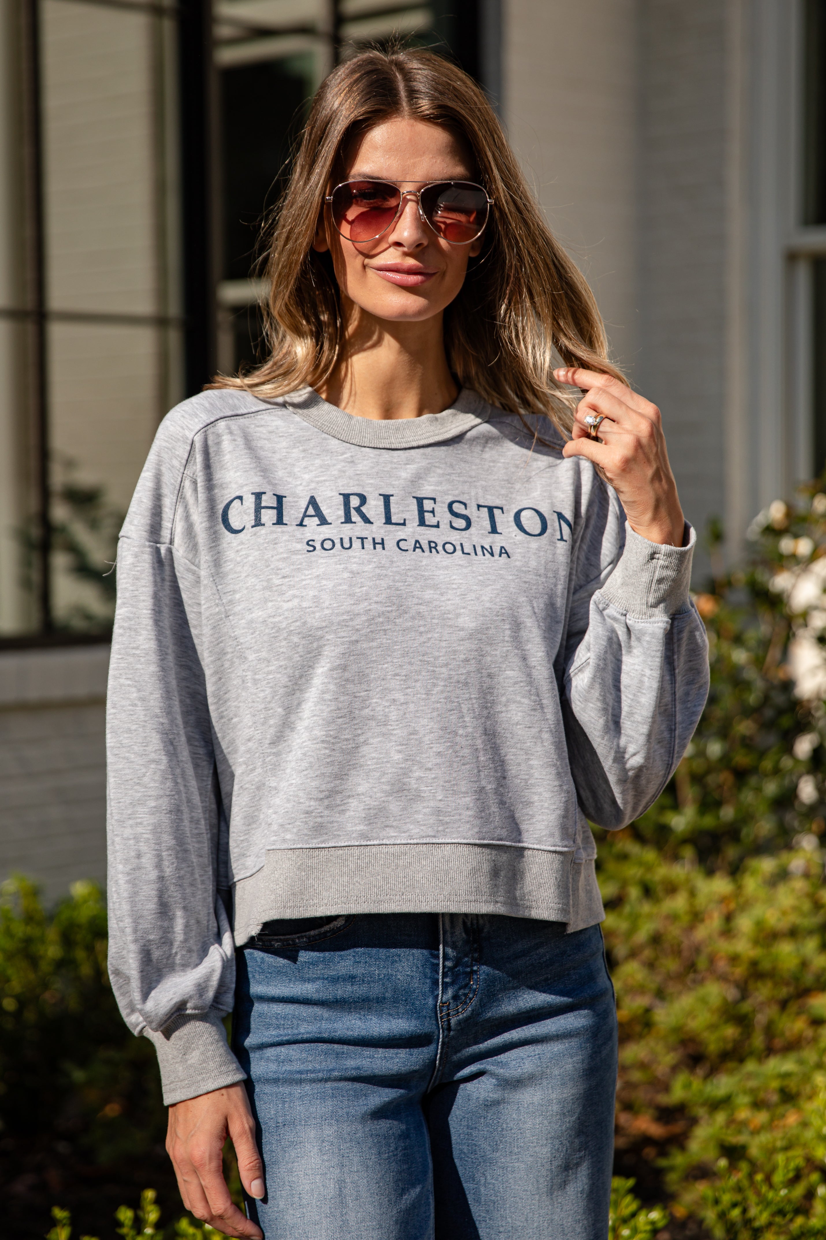 Woman wearing a gray sweatshirt with &