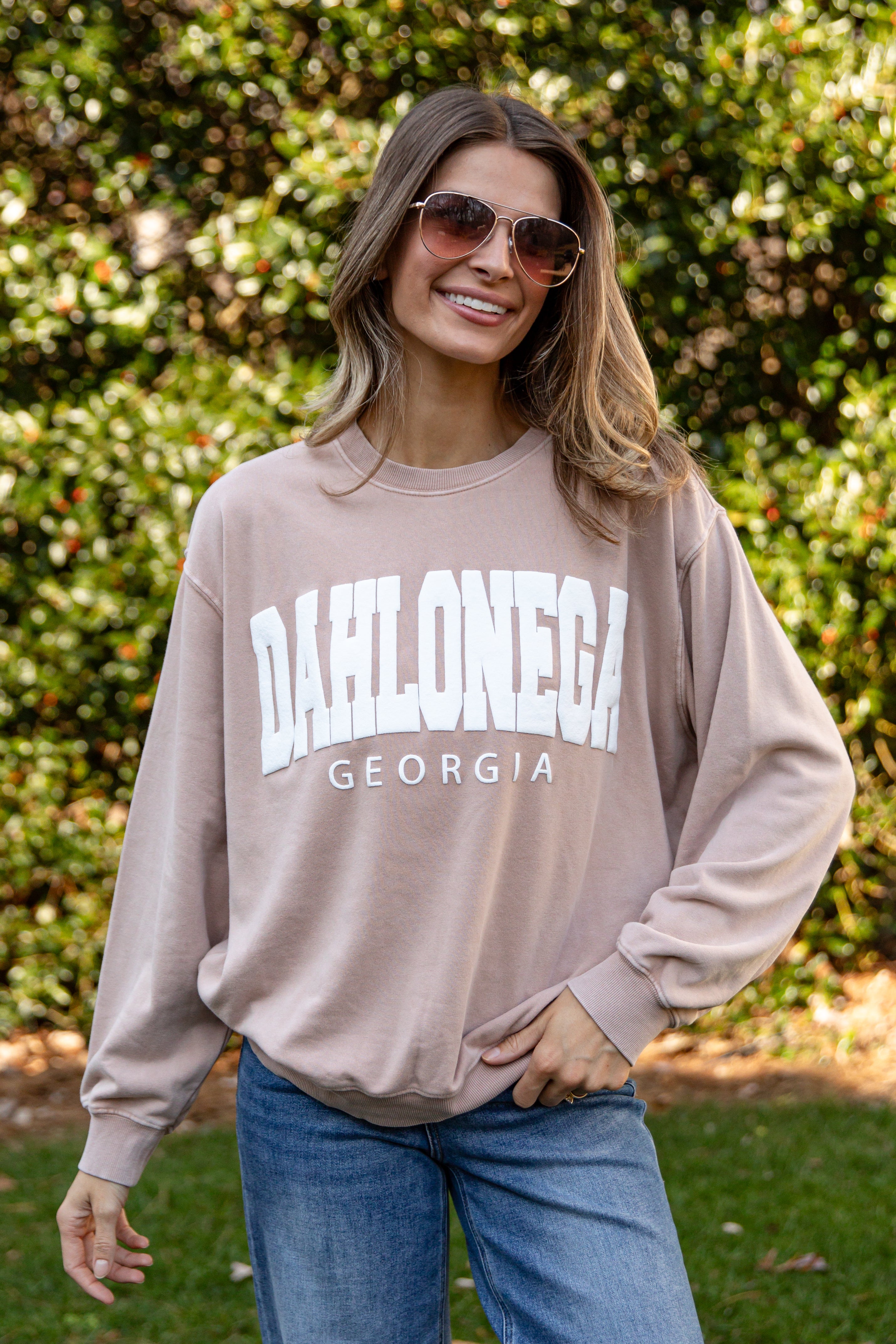 Woman wearing a beige sweatshirt with &