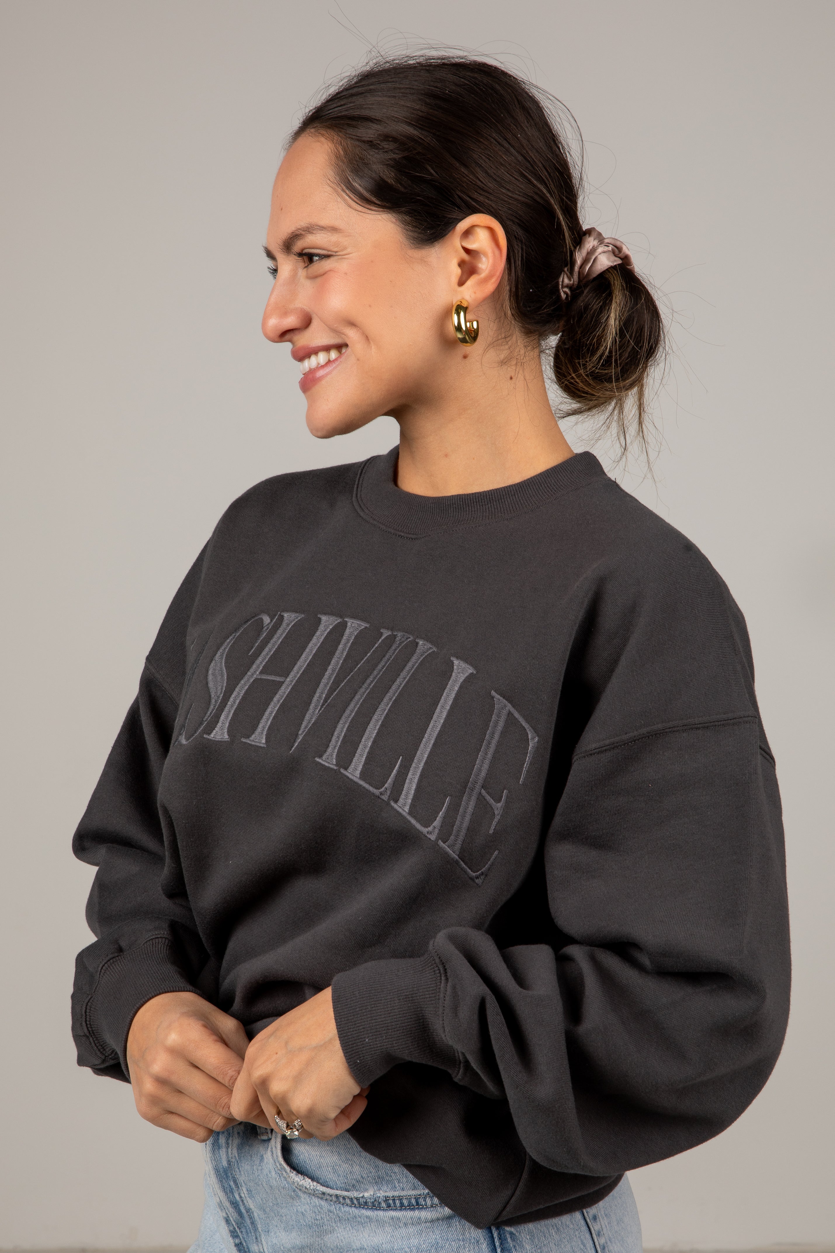 Woman wearing a black sweatshirt with &