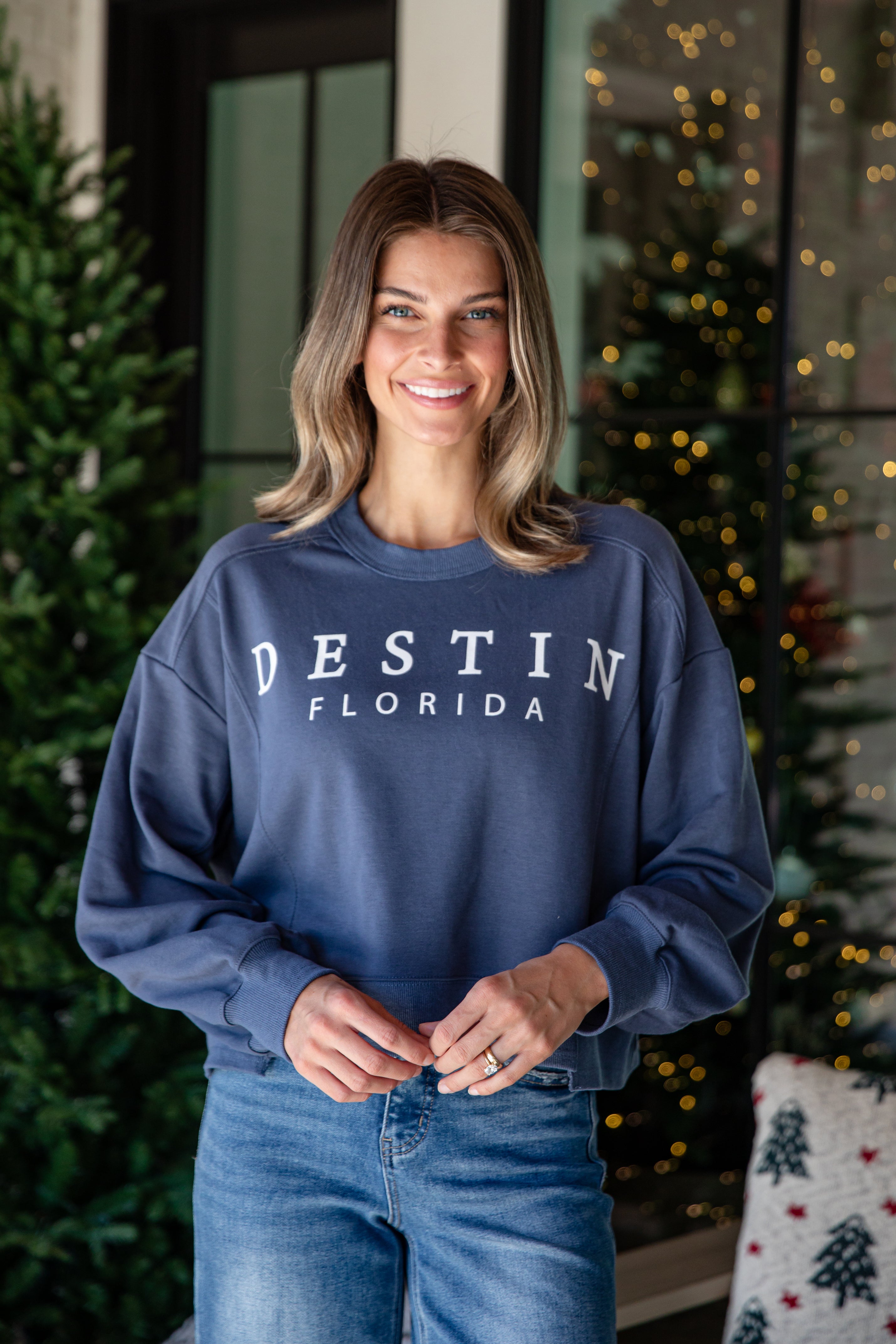 Woman wearing a navy blue sweatshirt with &