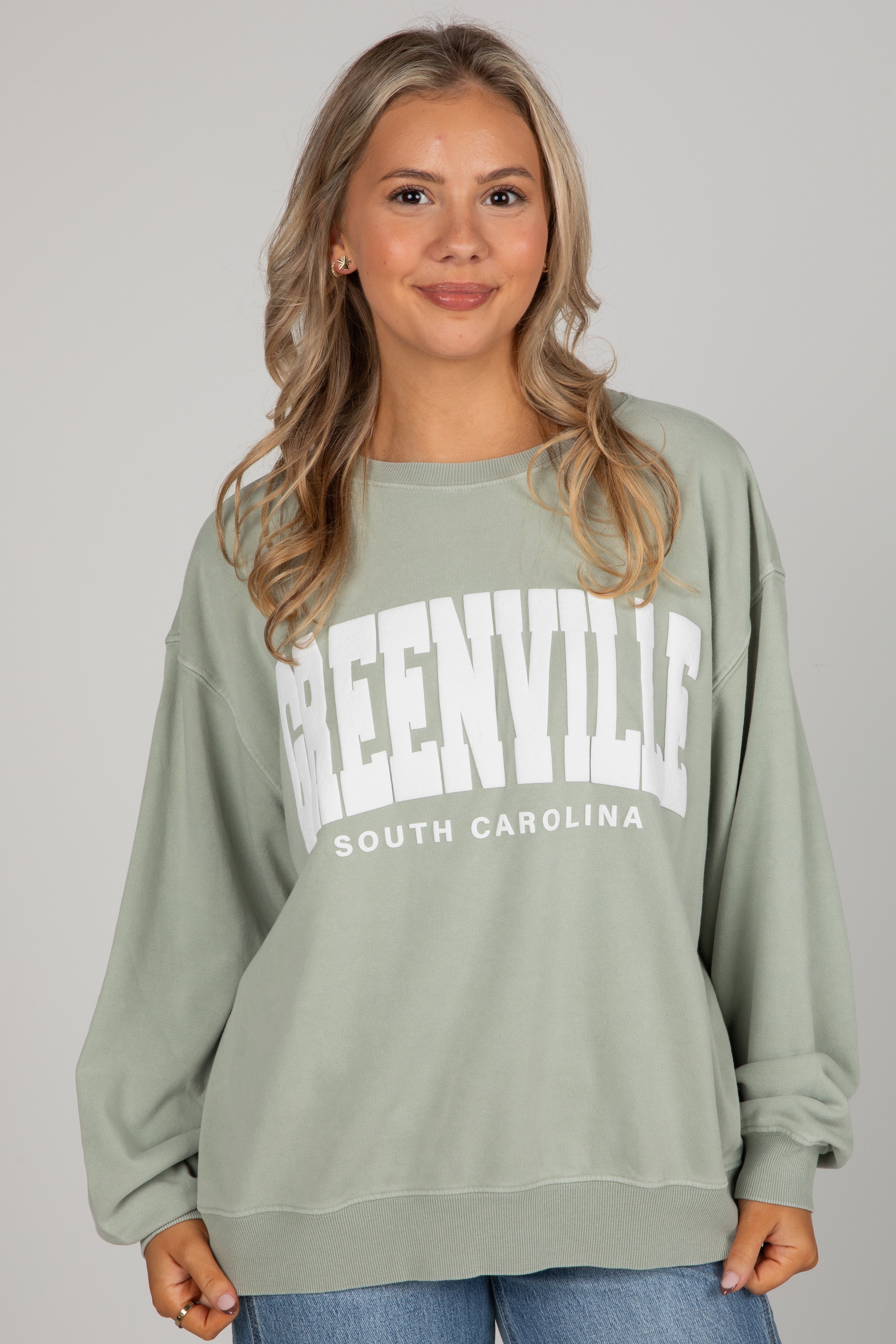 Woman wearing a green sweatshirt with &