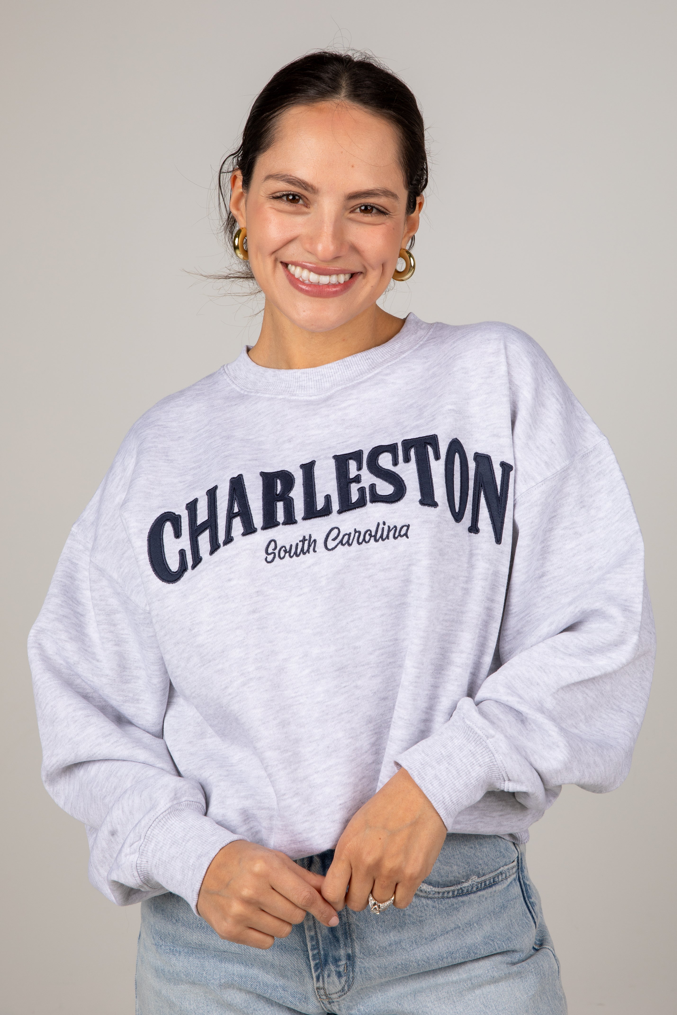 Woman wearing a gray sweatshirt with &