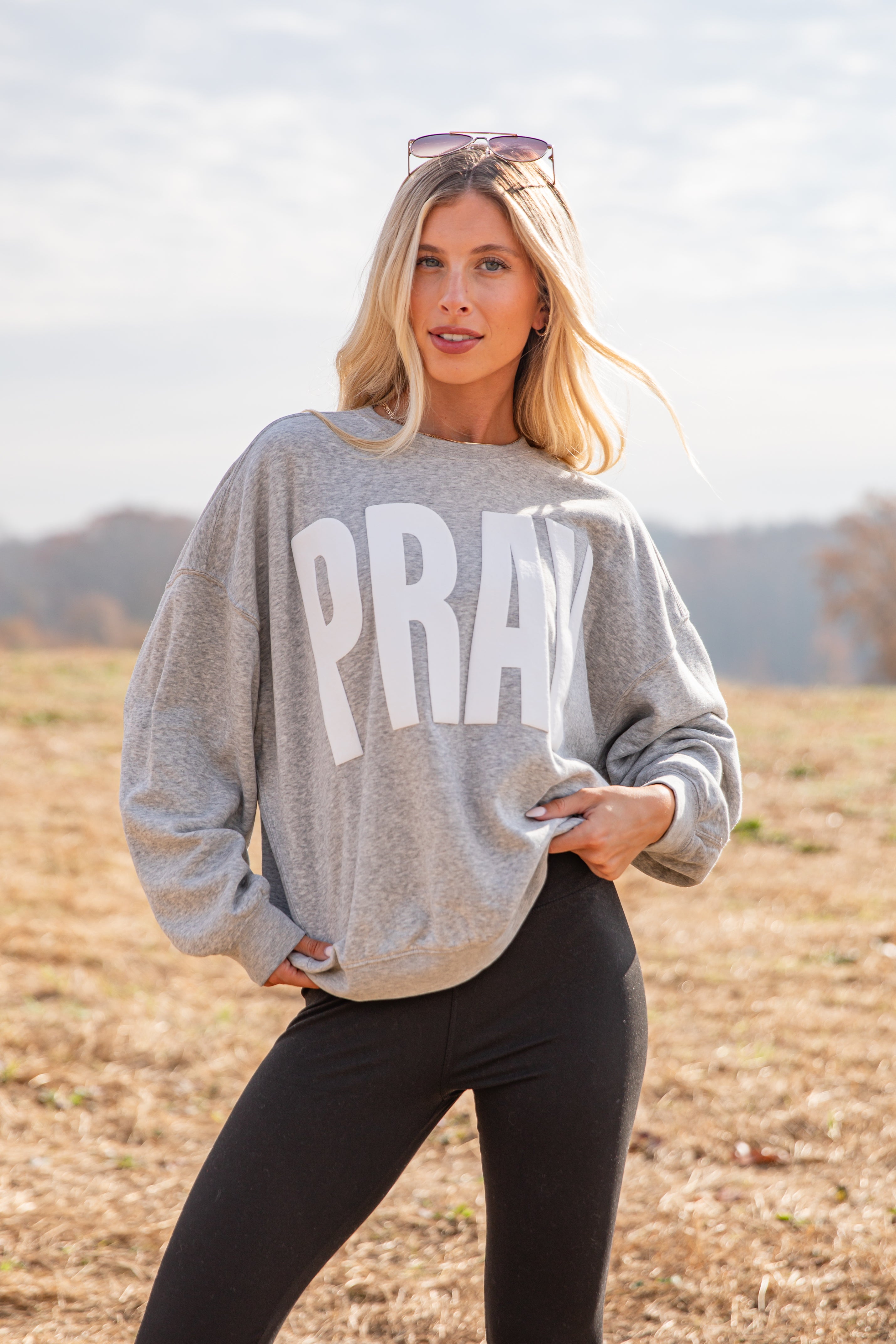 Woman wearing a gray sweatshirt with &